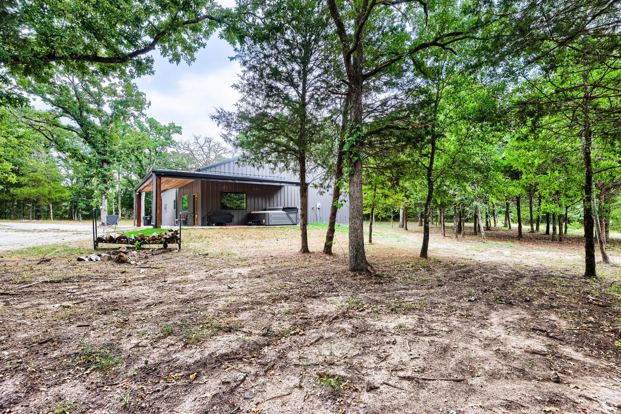 Private 5 acred wooded lot looking back toward home featuring expansive L-shaped porch with spa.