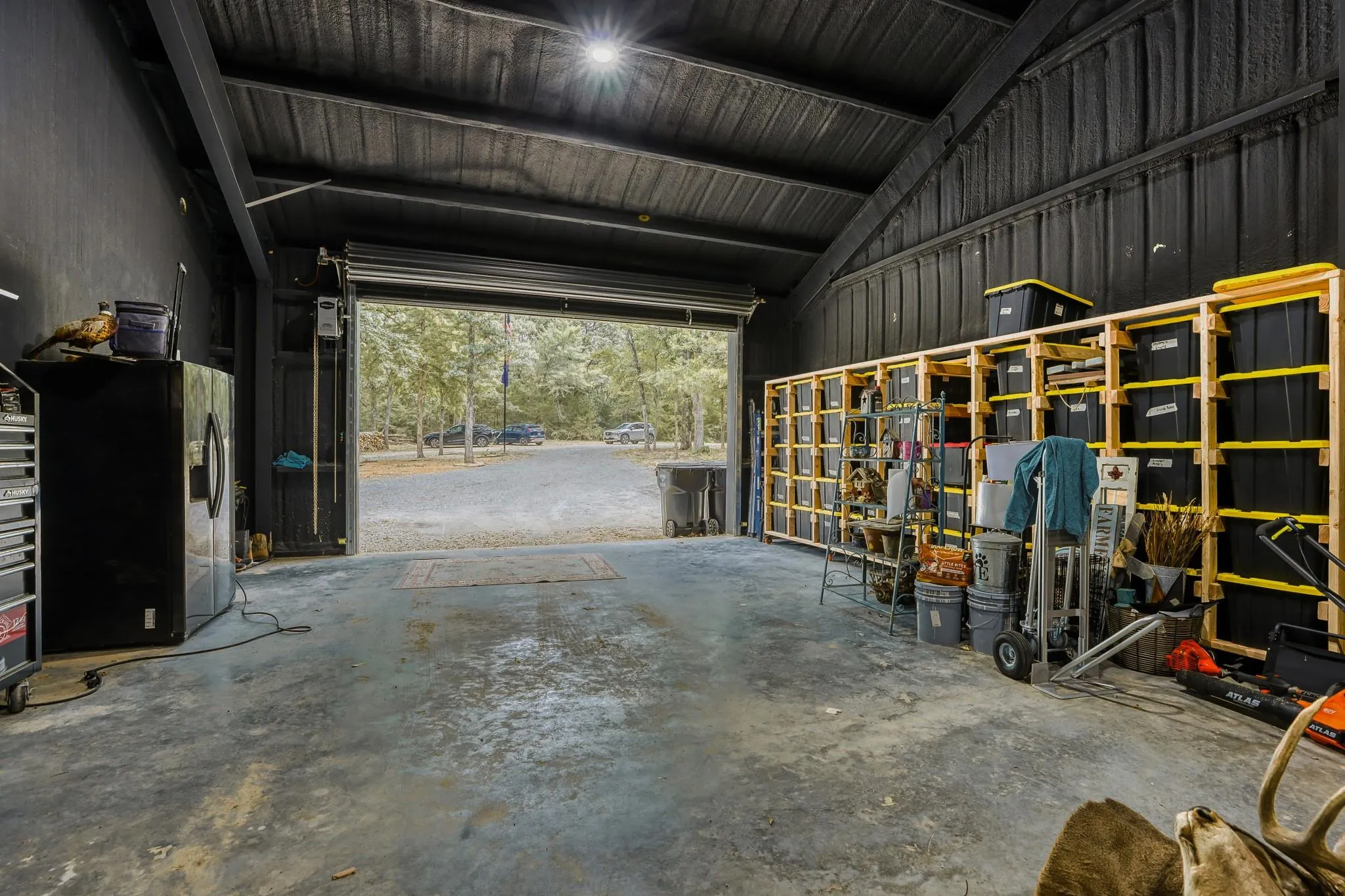 Oversized attached flexible garage/shop featuring a commercial door and high vaulted ceilings.