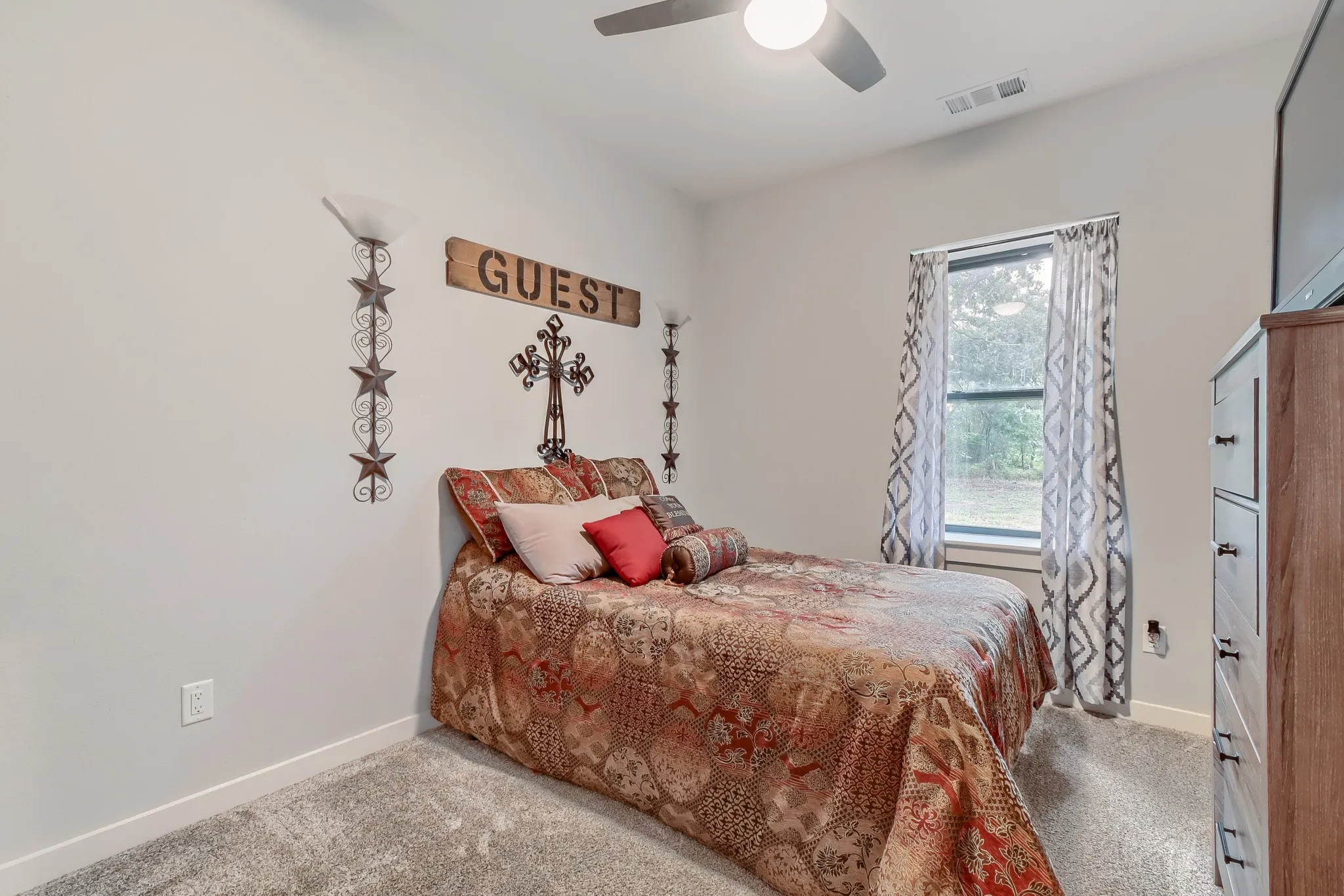 Secondary bedroom featuring a window overlooking 5 private acres with light painted walls and ceiling fan.