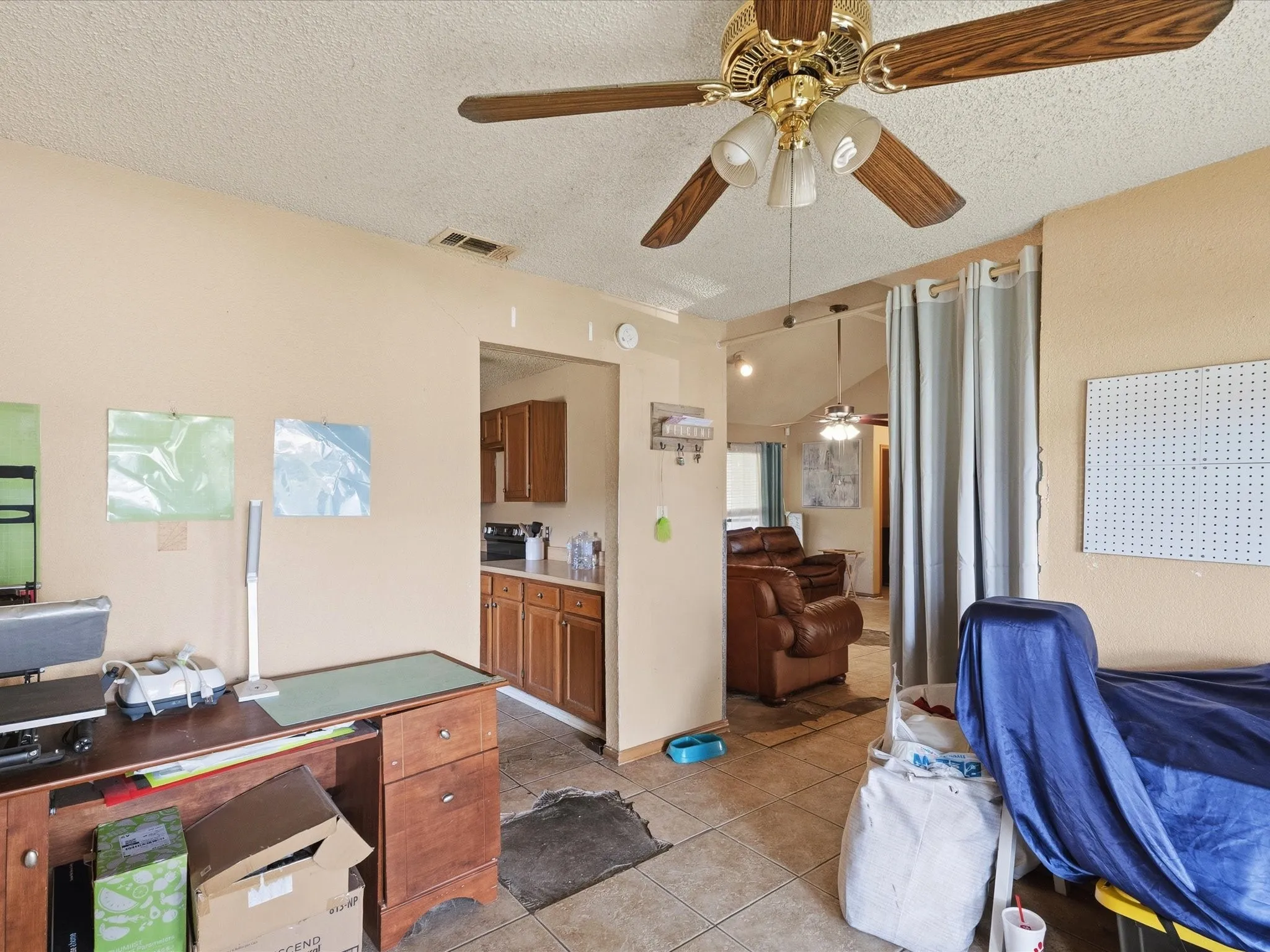 Open-concept room featuring a ceiling fan, tiled flooring, and neutral wall tones