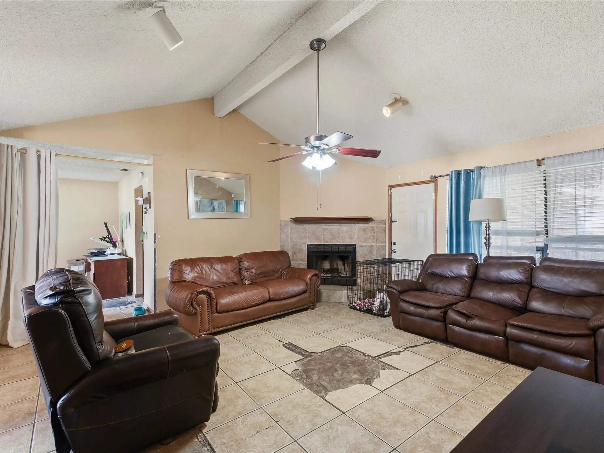Spacious living area featuring a vaulted ceiling and exposed beams