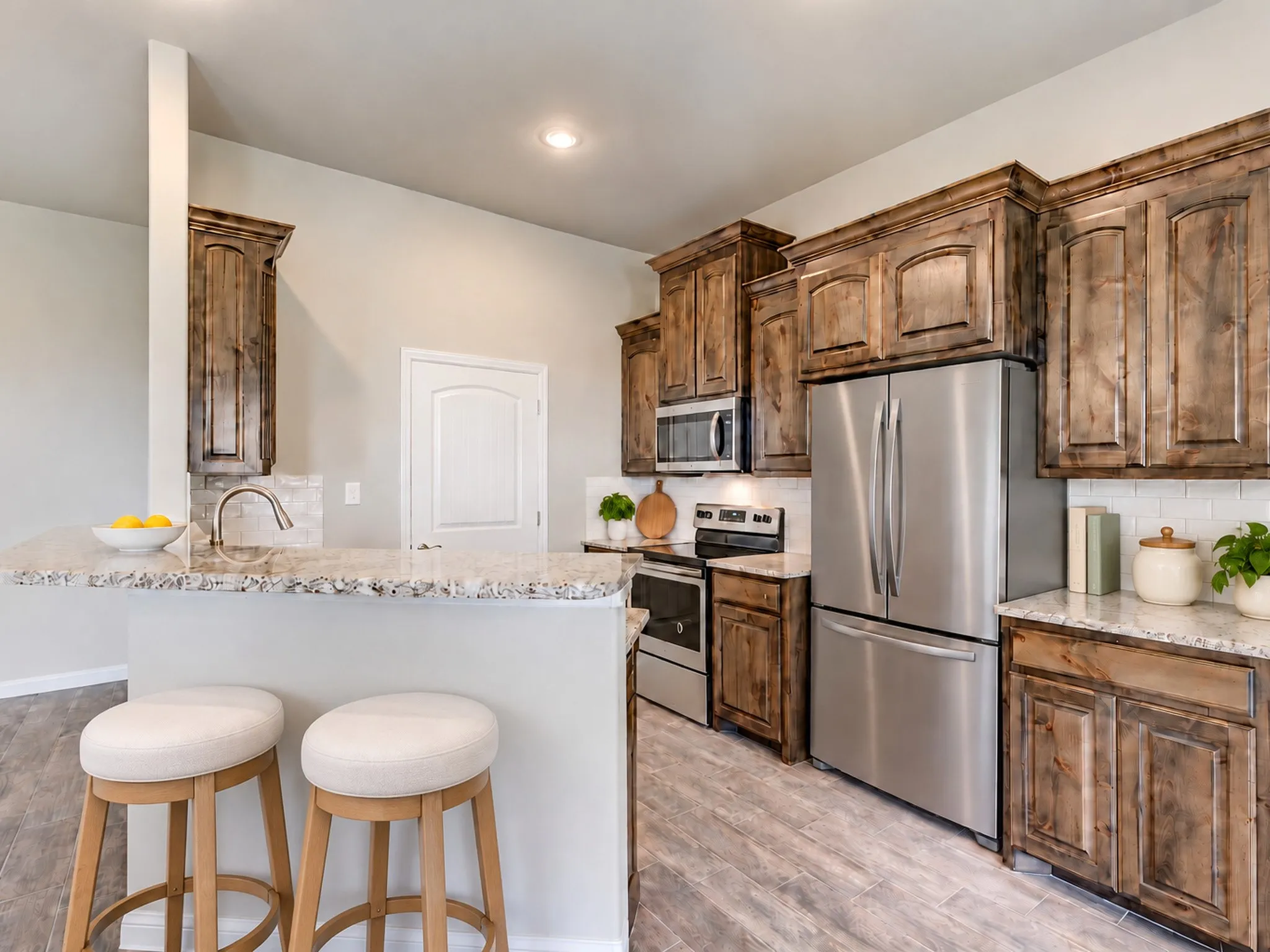 Kitchen with wood-finish cabinetry, stainless steel appliances, granite countertops, and a subway tile backsplash
