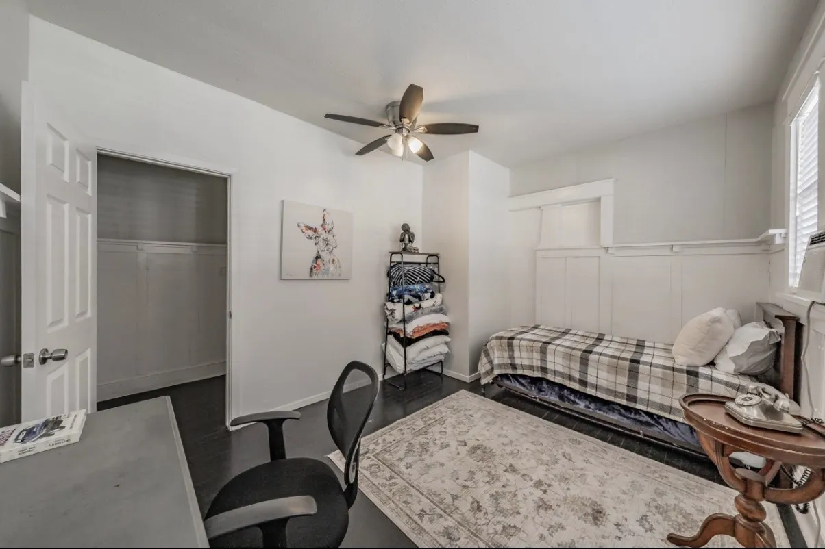 Room featuring dark wood-finish flooring, a ceiling fan with integrated lighting, and a closet with a bi-fold door