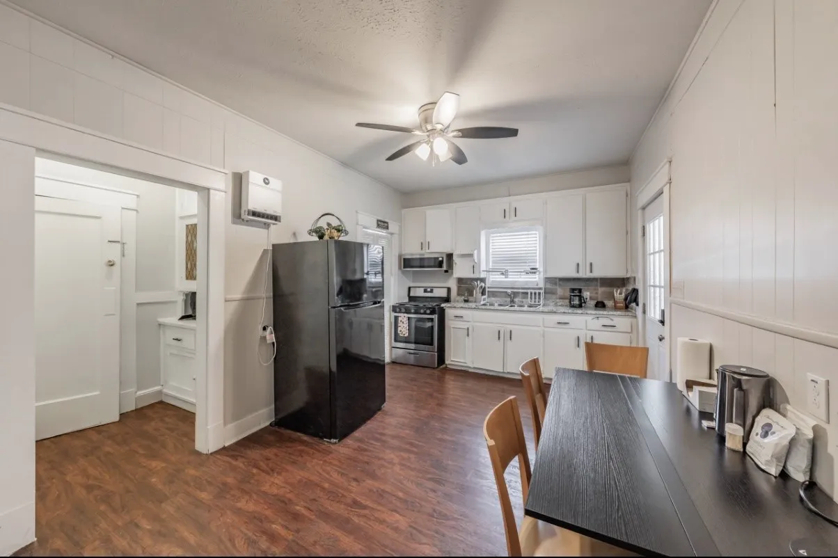 Kitchen featuring white cabinetry, stainless steel appliances, and a mosaic tile backsplash
