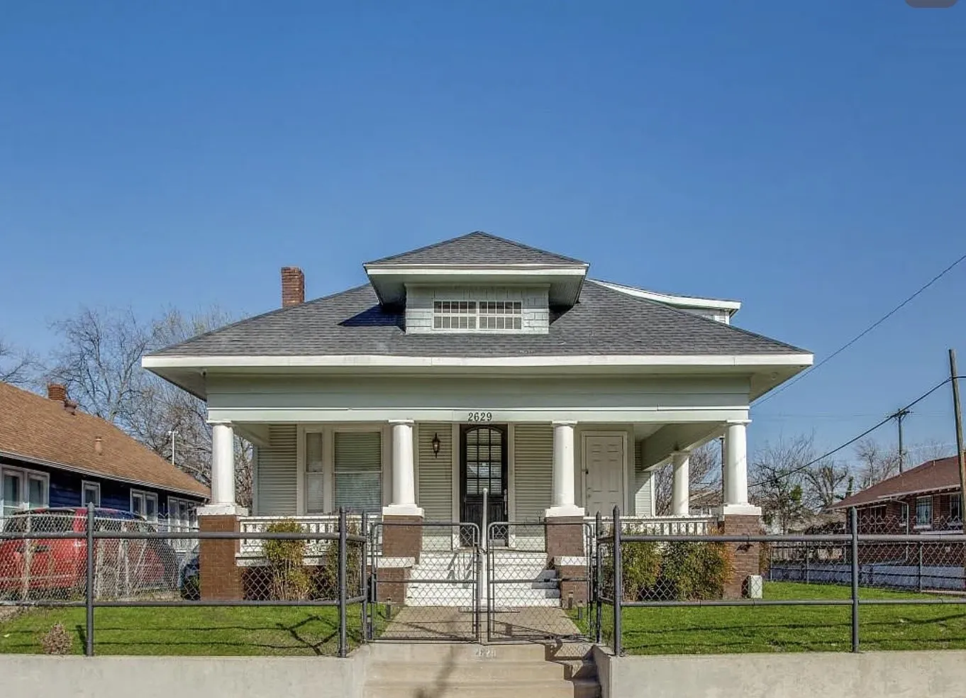 Classic bungalow-style residence featuring a prominent front porch with white columns and brick accents