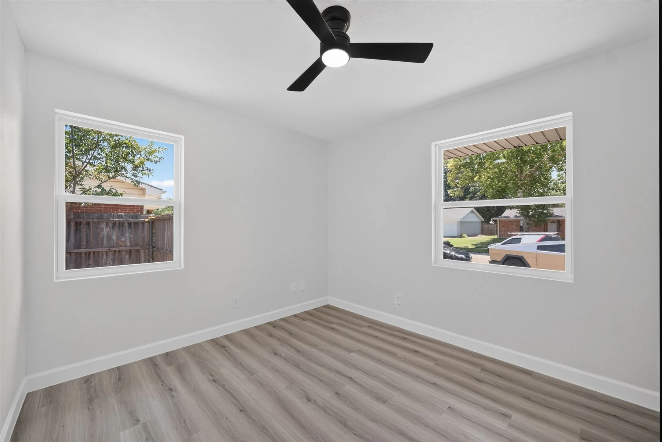 Bright interior space with light gray walls, white trim, and wood-finish flooring