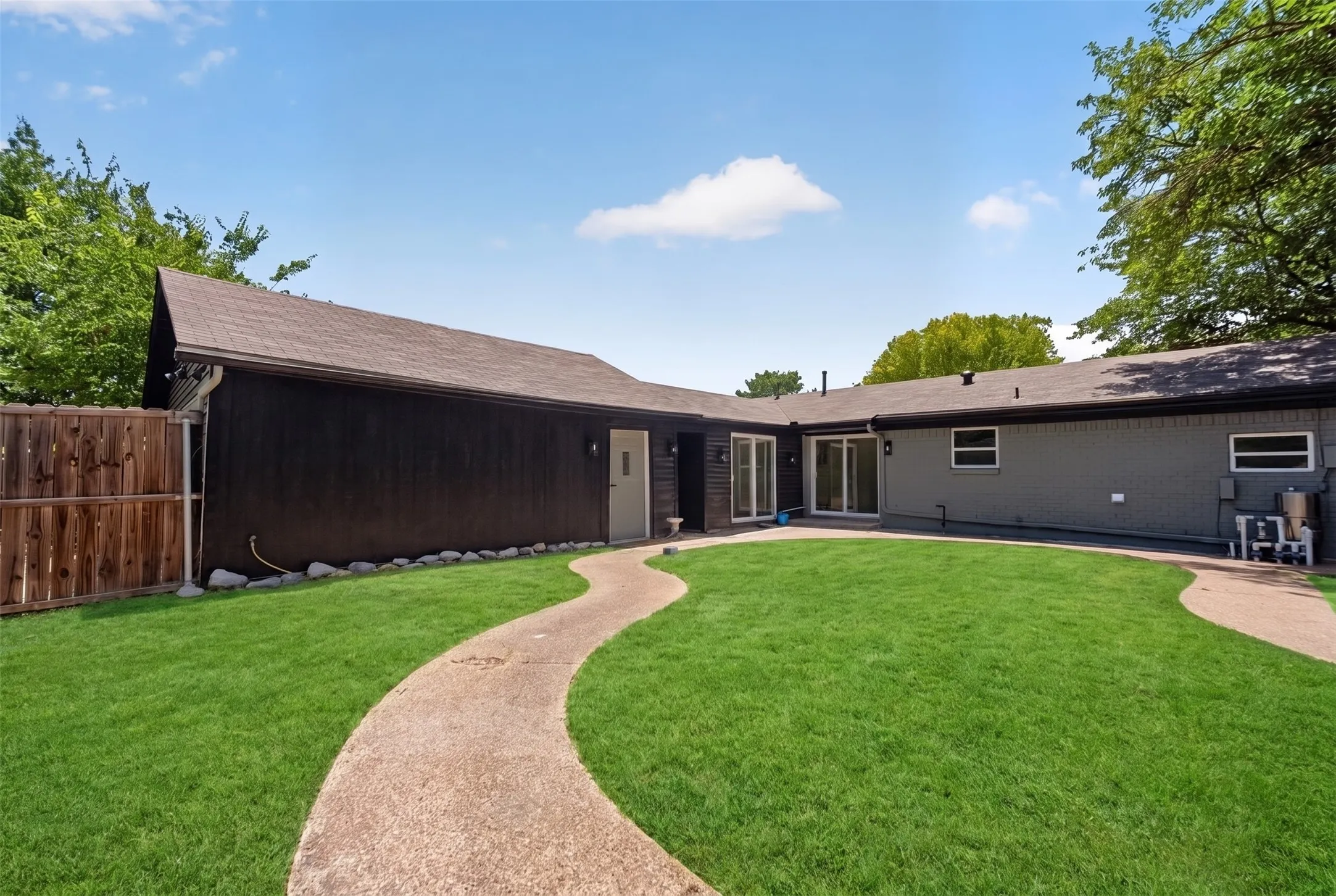 Expansive green lawn with a winding concrete pathway