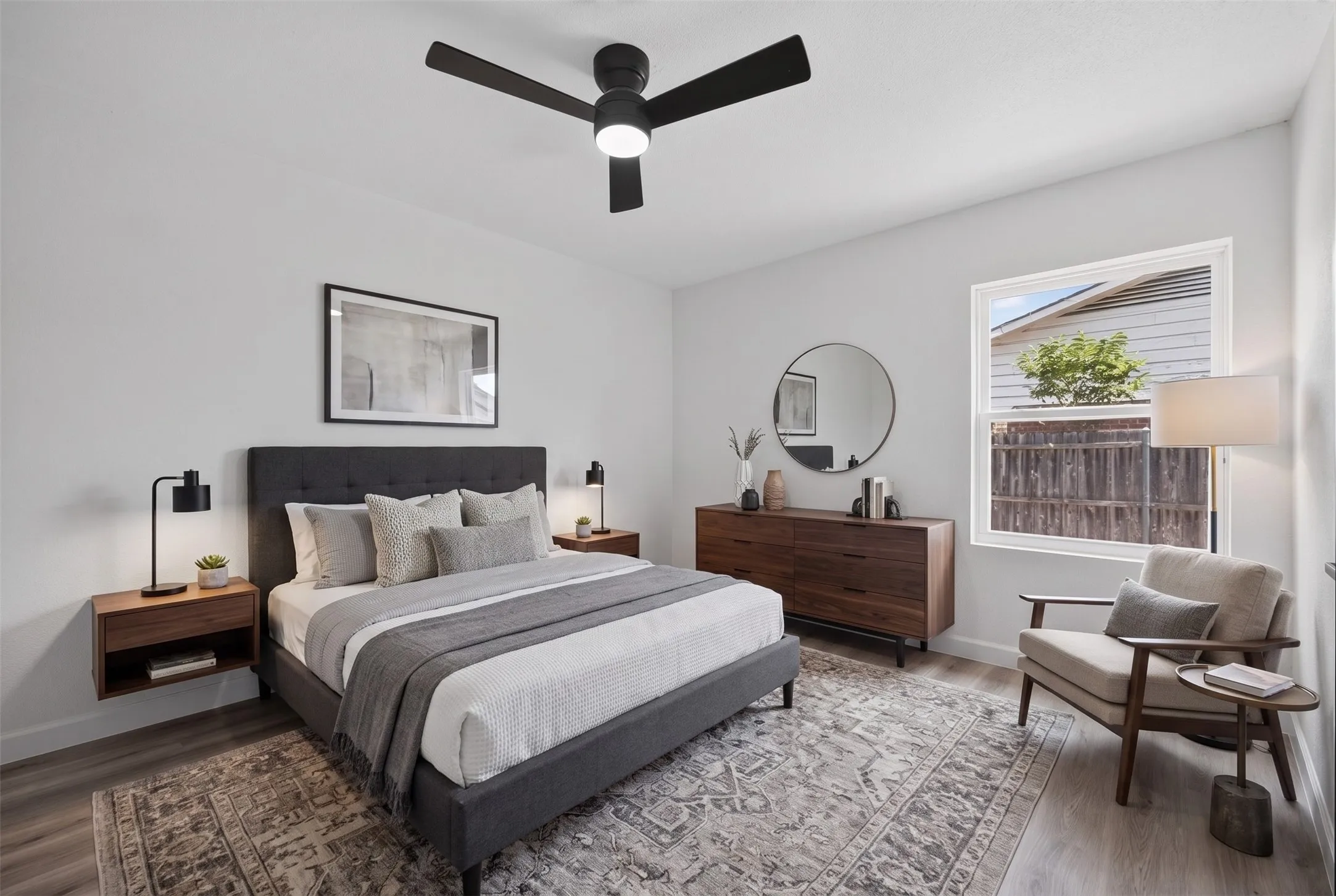 Spacious room featuring wood-finish flooring, a contemporary ceiling fan, and a large window