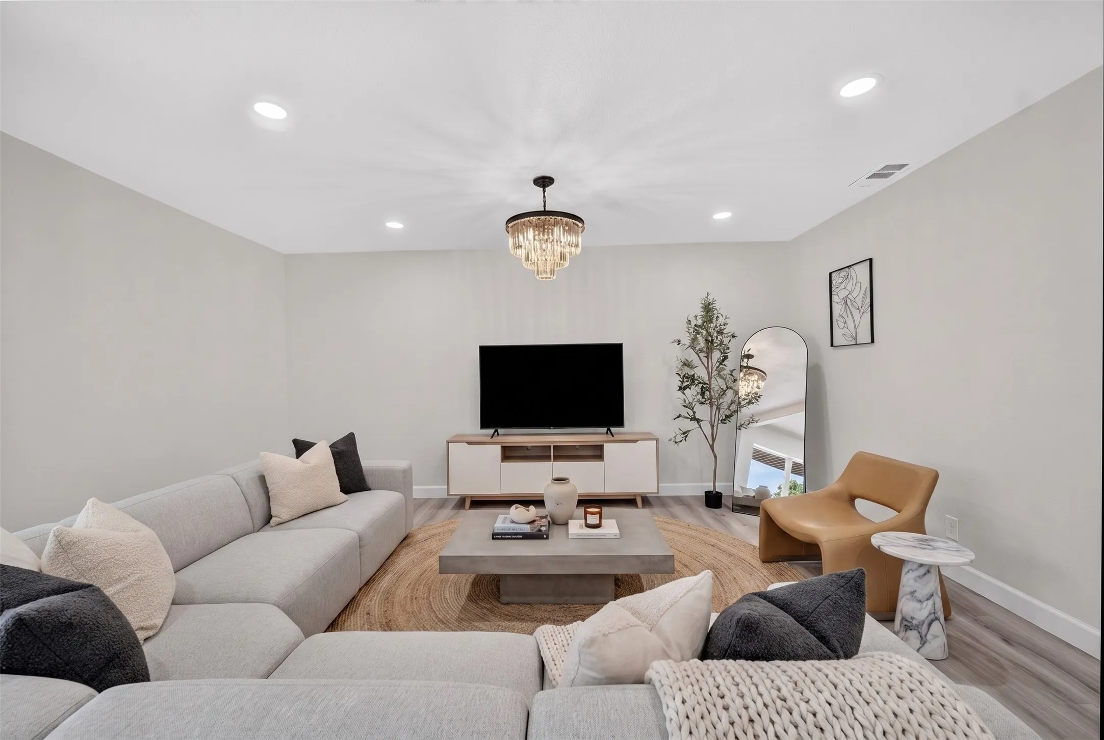 Living area featuring recessed lighting and a tiered chandelier