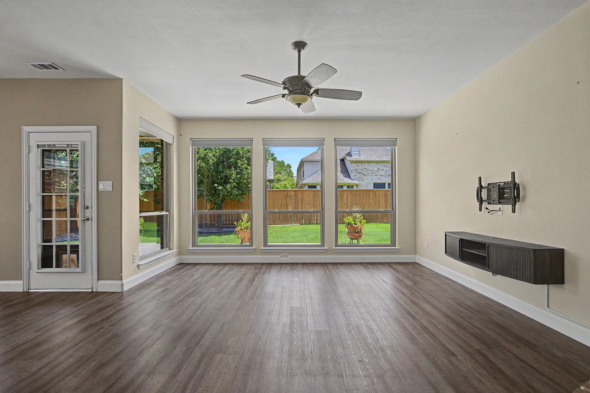 Family room is ready for your flat screen TV featuring concealed cord storage, a wall of windows also equipped with motorized shades with remotes