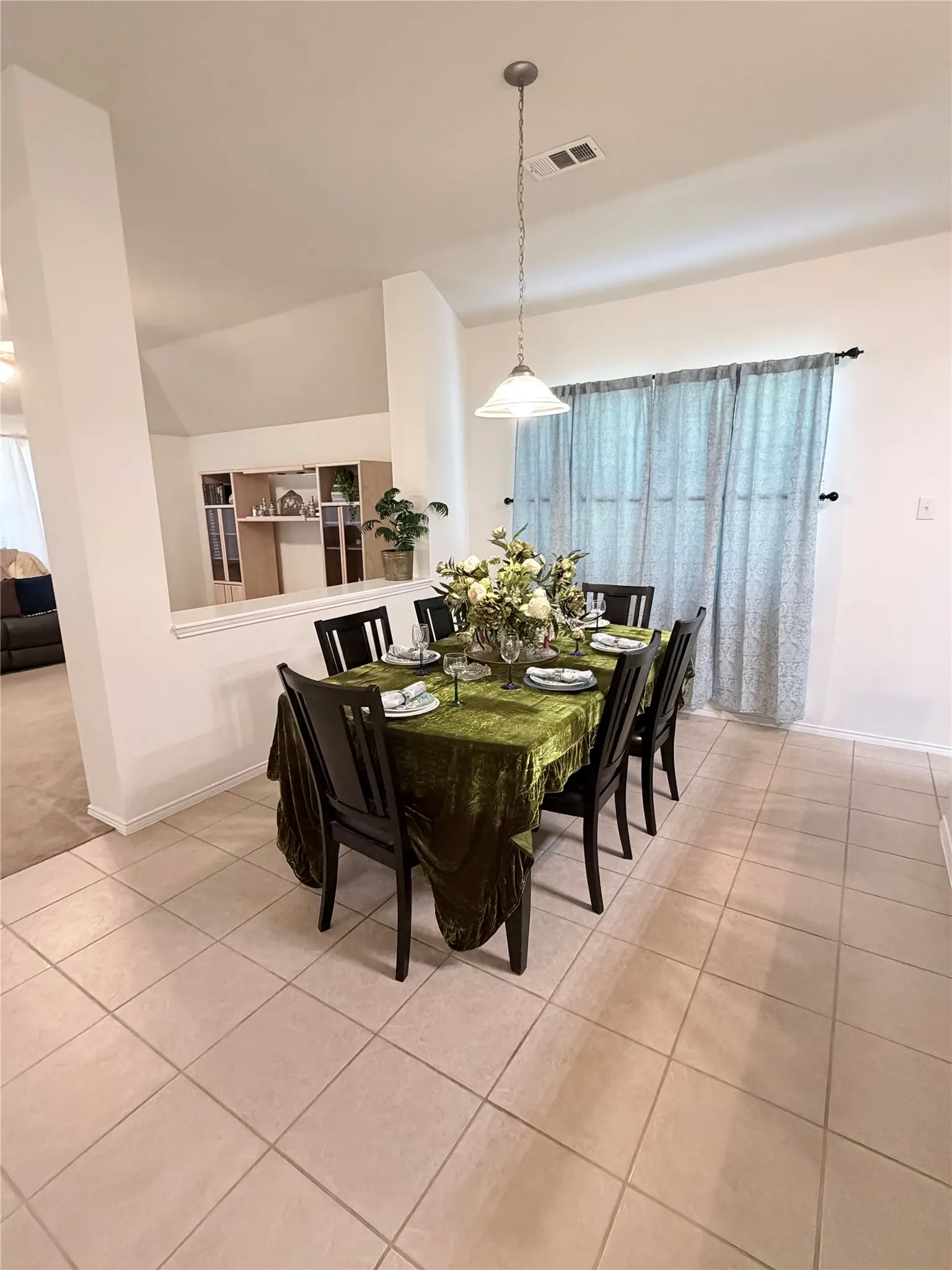 Recessed lighting with a pendant light fixture illuminates the space