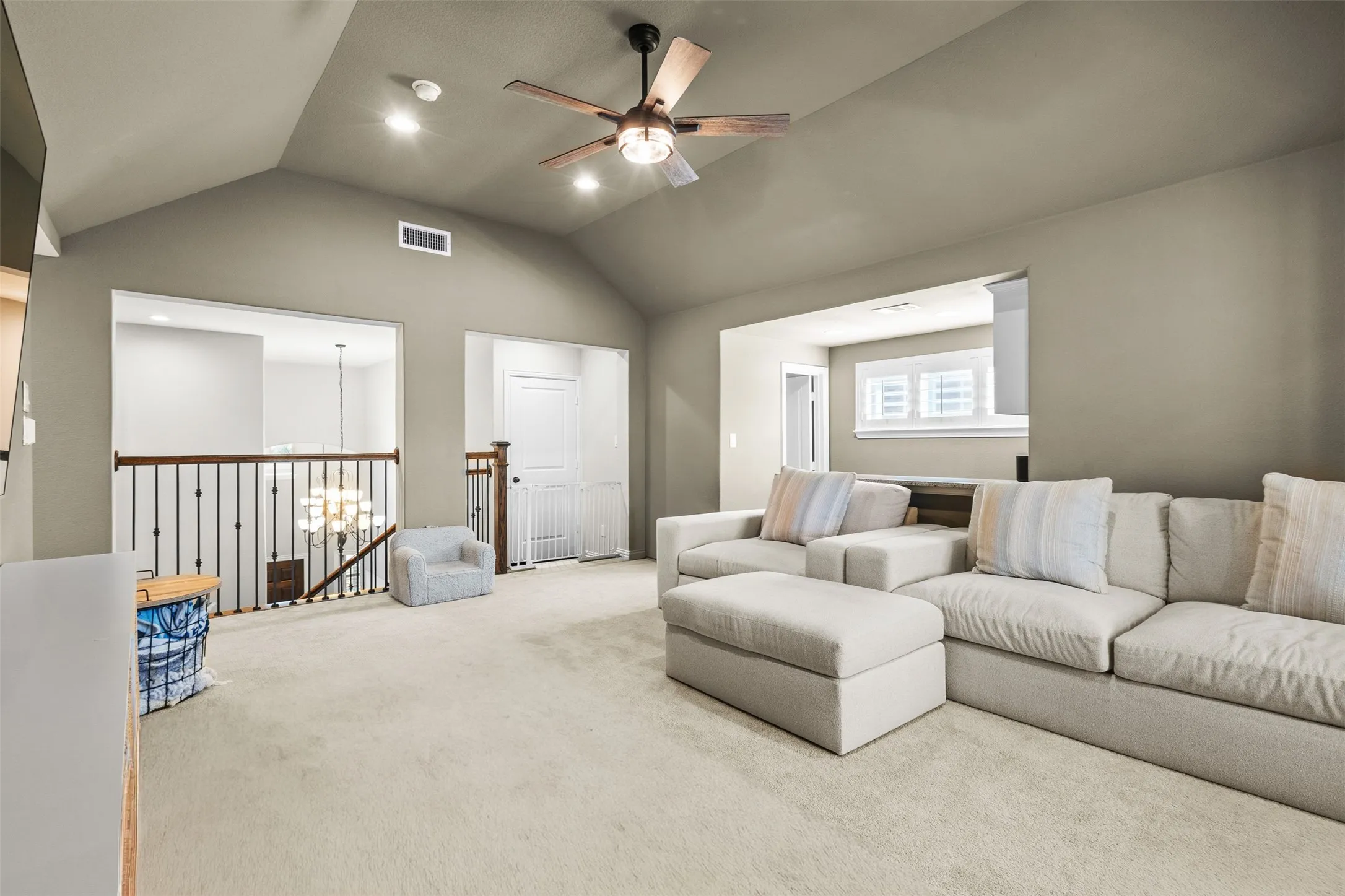 Spacious upper-level room featuring a vaulted ceiling and recessed lighting