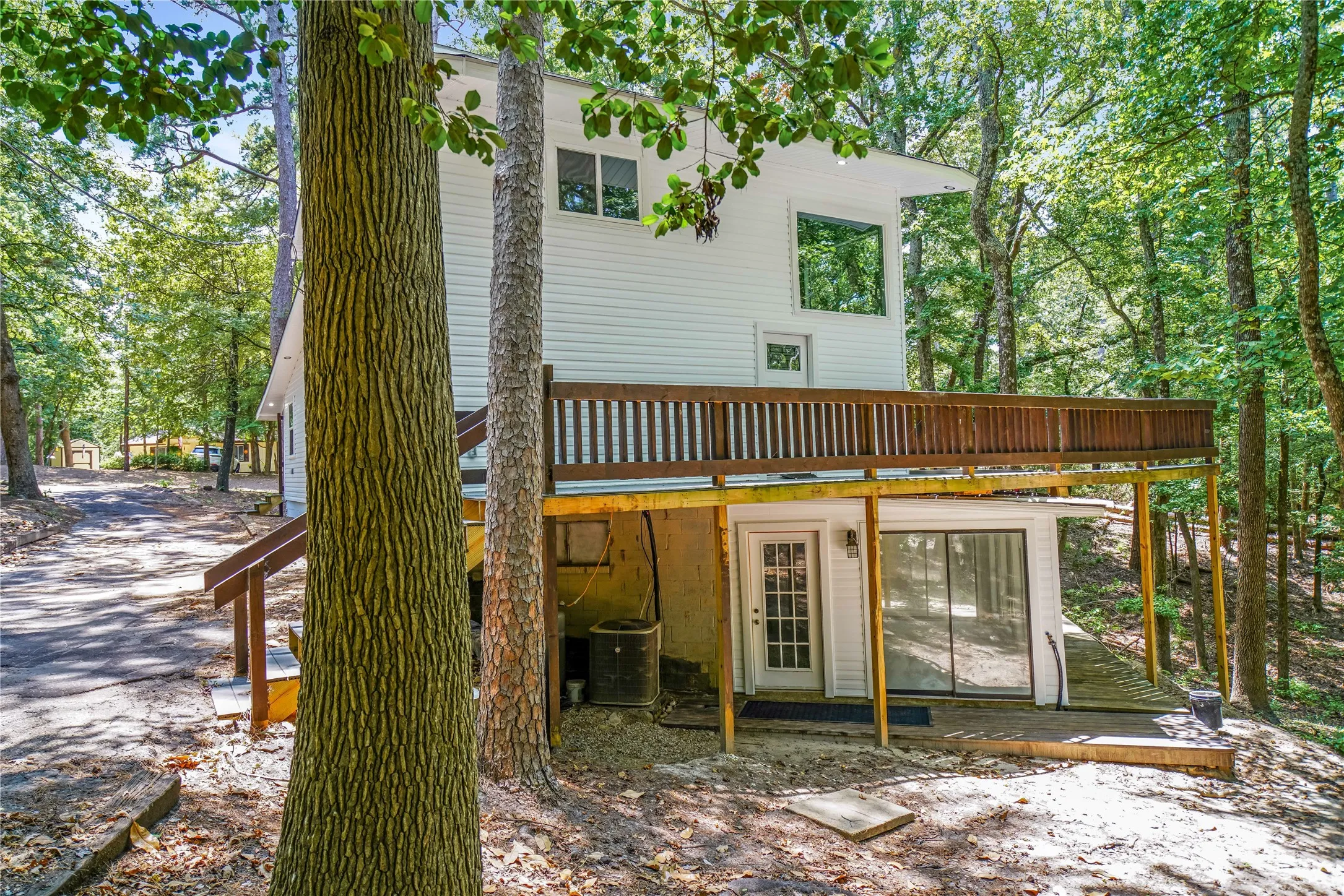 Two-story residence with white siding and an elevated wood deck