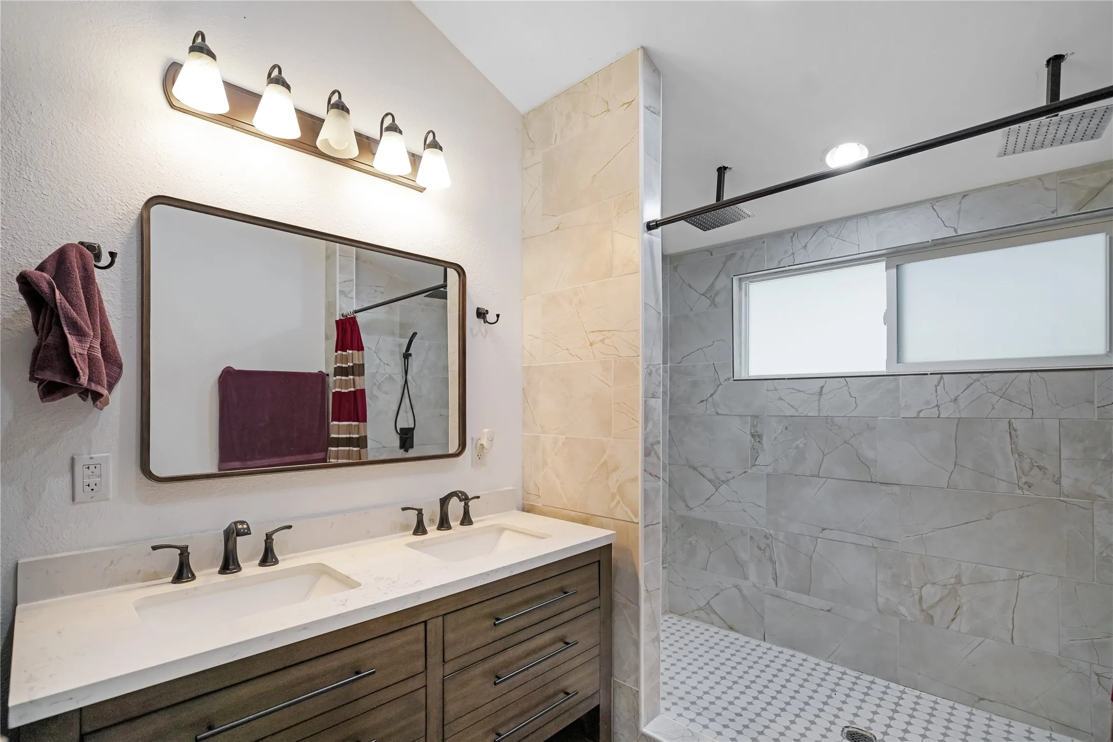 Double vanity with integrated sinks and dark bronze fixtures set against a white countertop