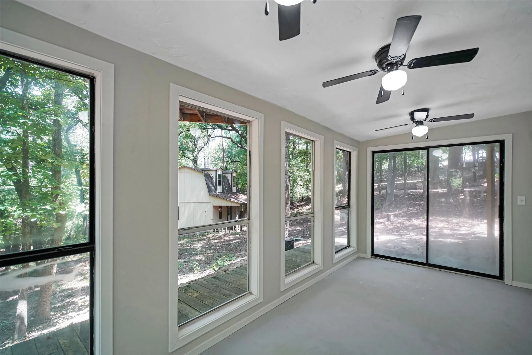 Room featuring multiple windows and a sliding glass door providing expansive outdoor views