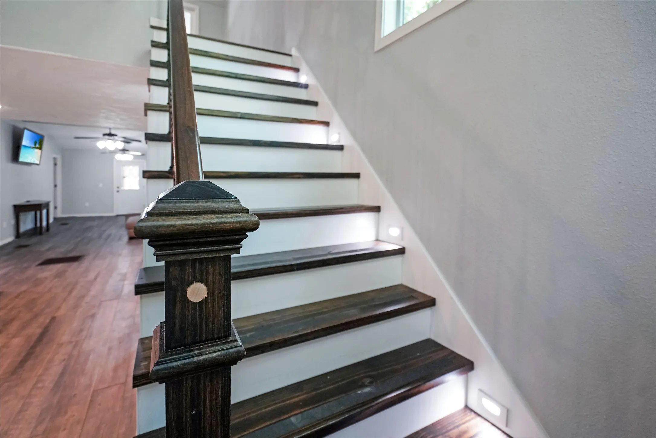 Staircase with wood-finish treads and risers, featuring integrated step lighting