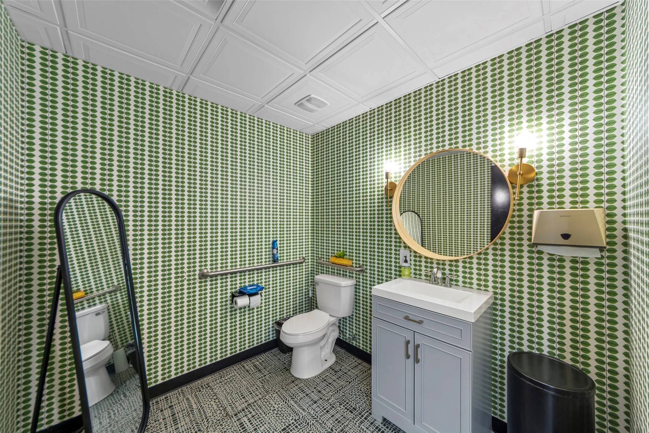 Powder room featuring bold green patterned wallpaper, a white pressed-tin ceiling, and patterned floor tiles