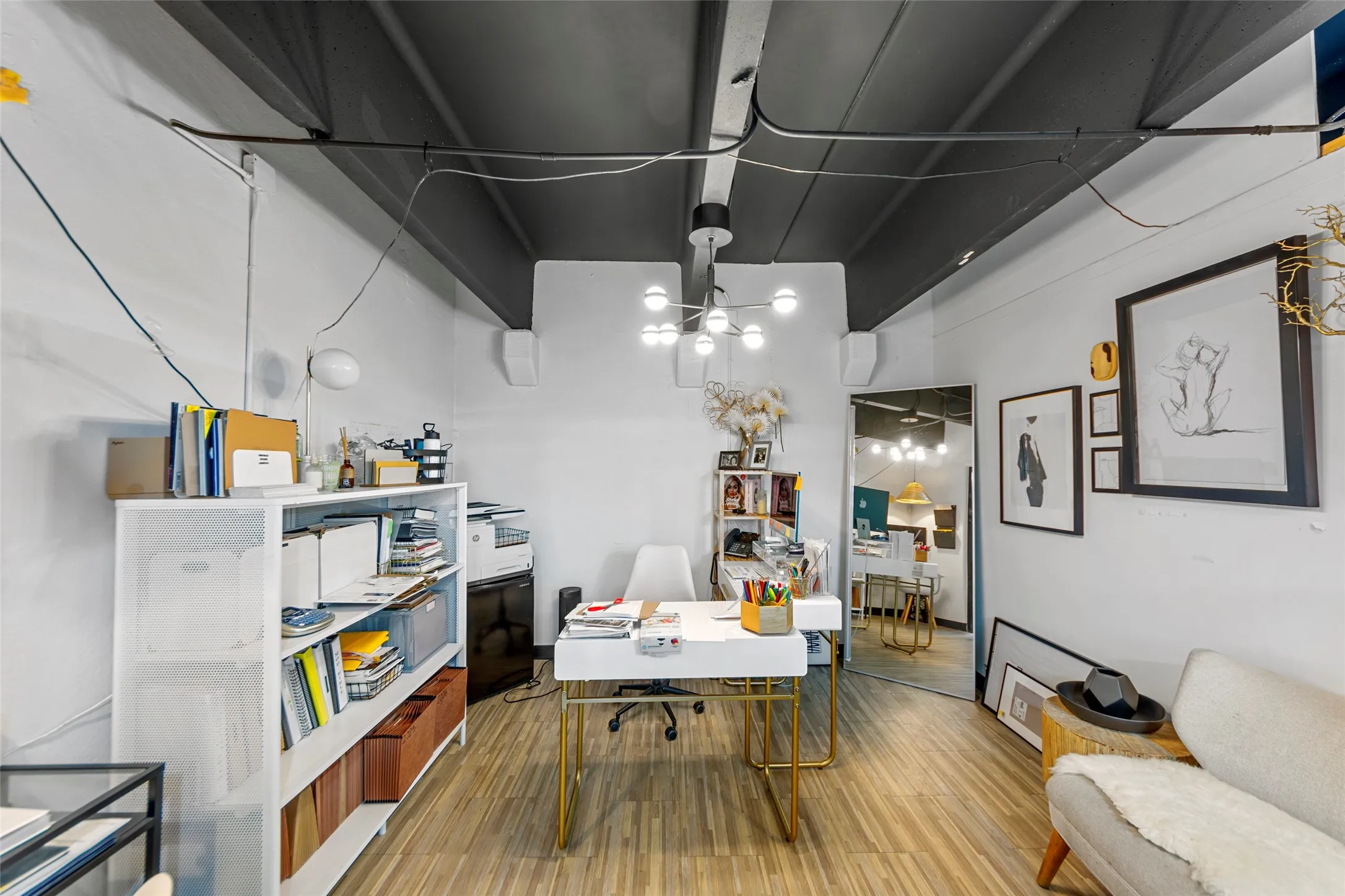 Room featuring wood-finish flooring, white walls, and a dark-painted ceiling with exposed conduit