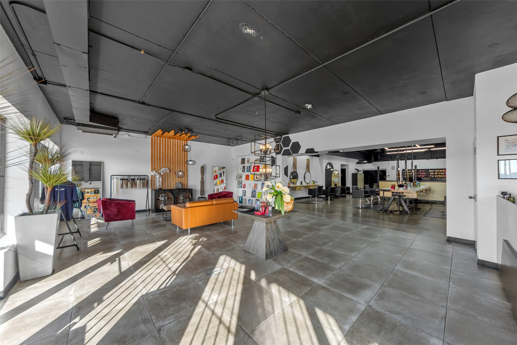 Spacious interior featuring a dark ceiling, recessed lighting, large format tile flooring, and ample natural light through extensive windows