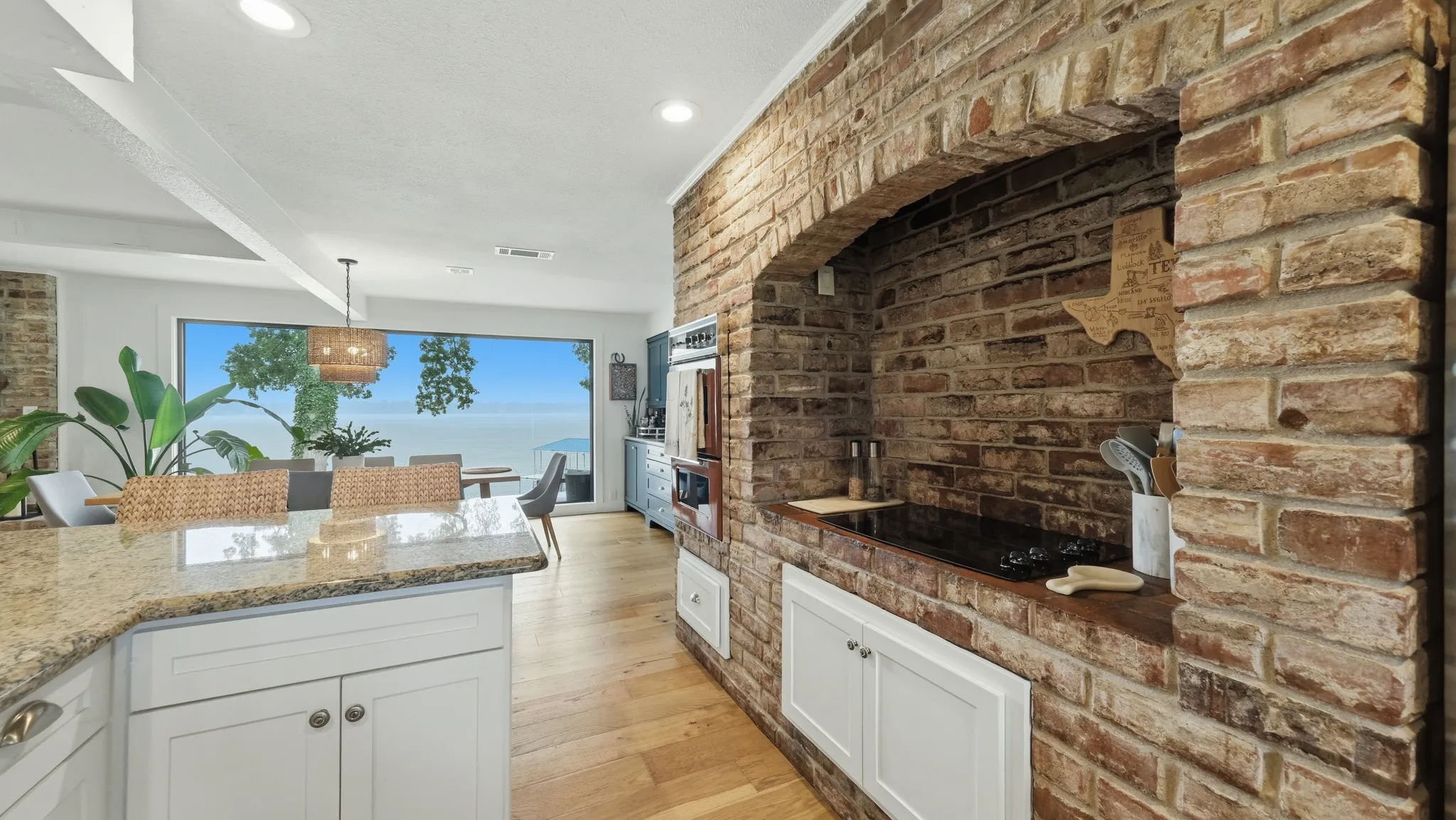 Kitchen featuring a built-in brick cooktop, integrated oven, and granite countertops