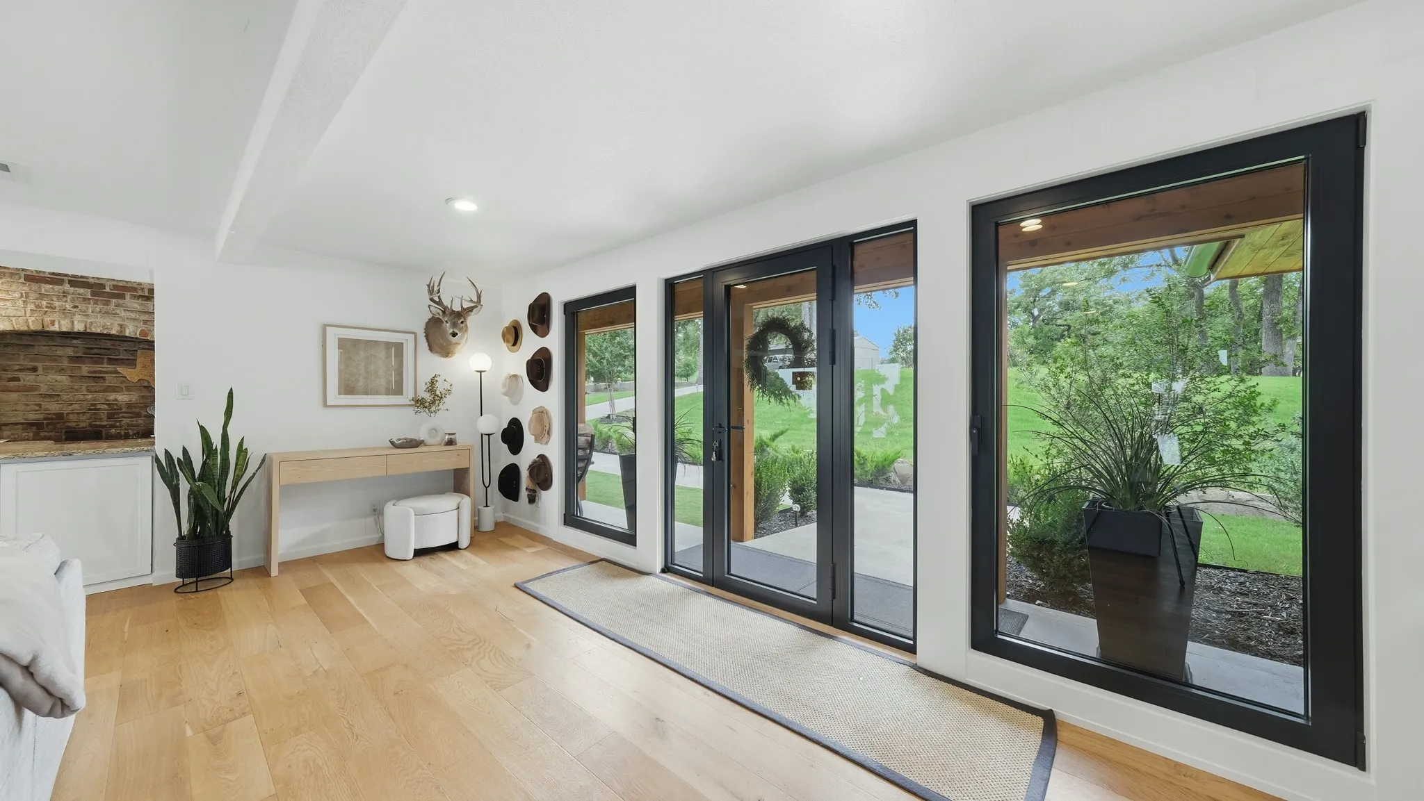 Hardwood flooring present in an open room with white walls and recessed lighting