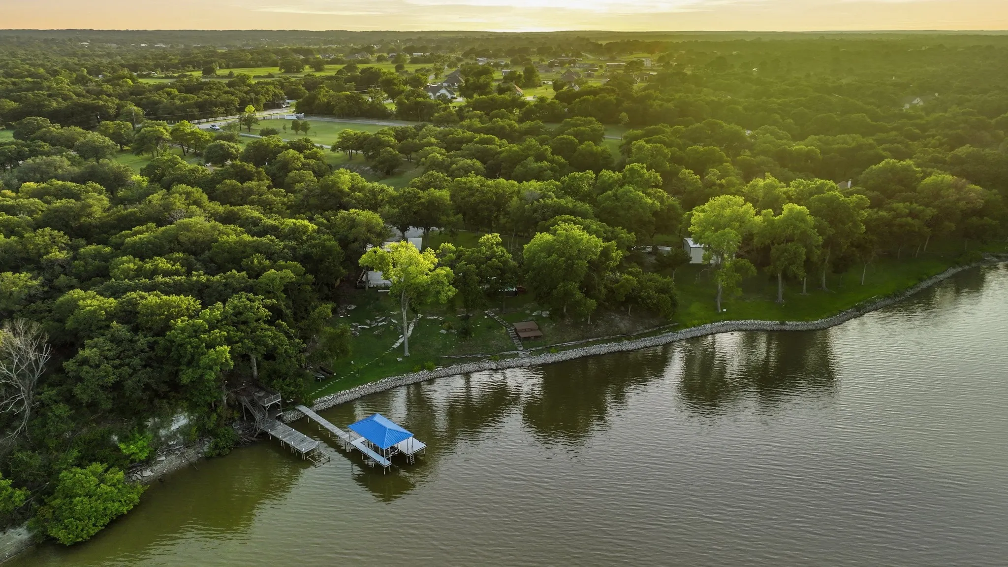 Expansive waterfront property featuring a private dock with covered boat slip