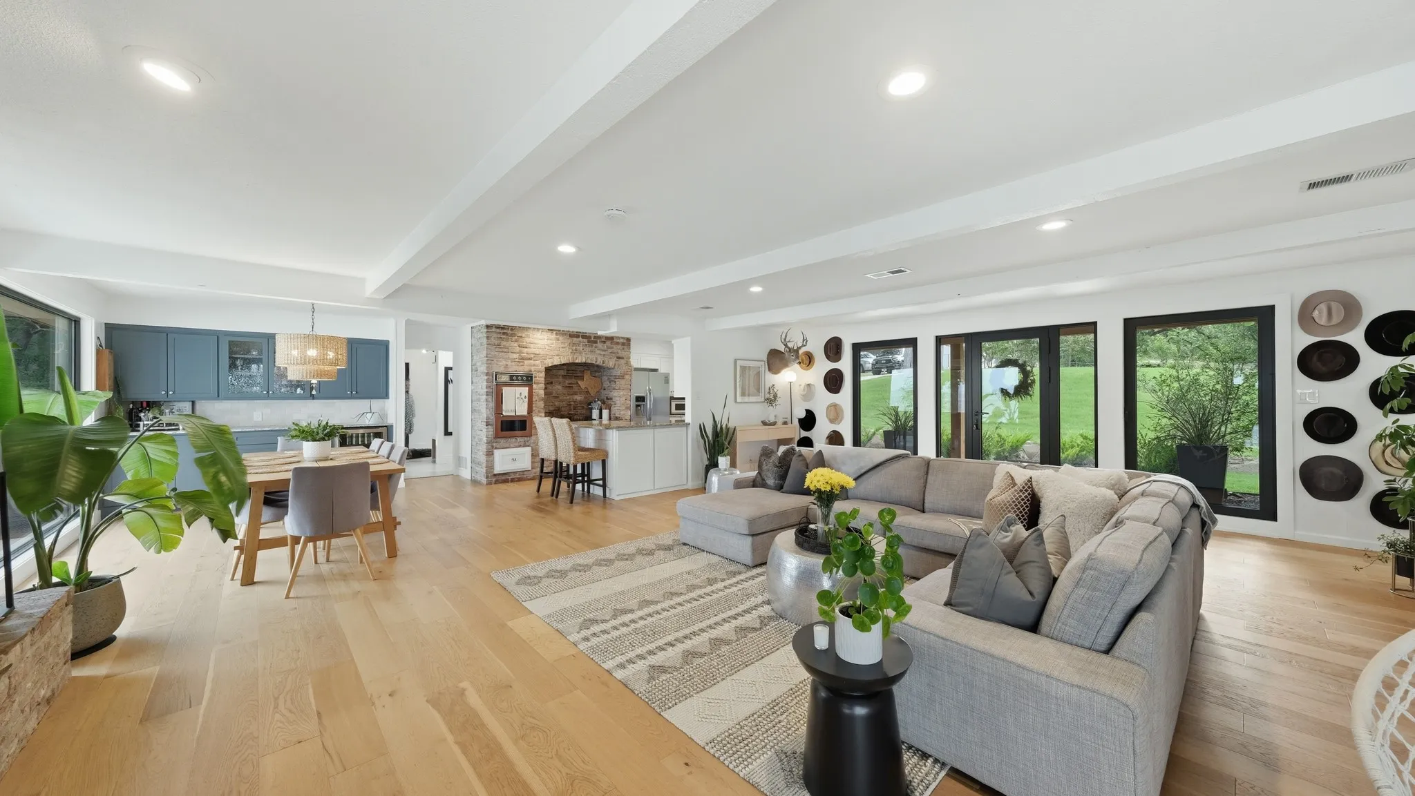 Open-concept living space featuring wood-finish flooring, recessed lighting, and expansive windows