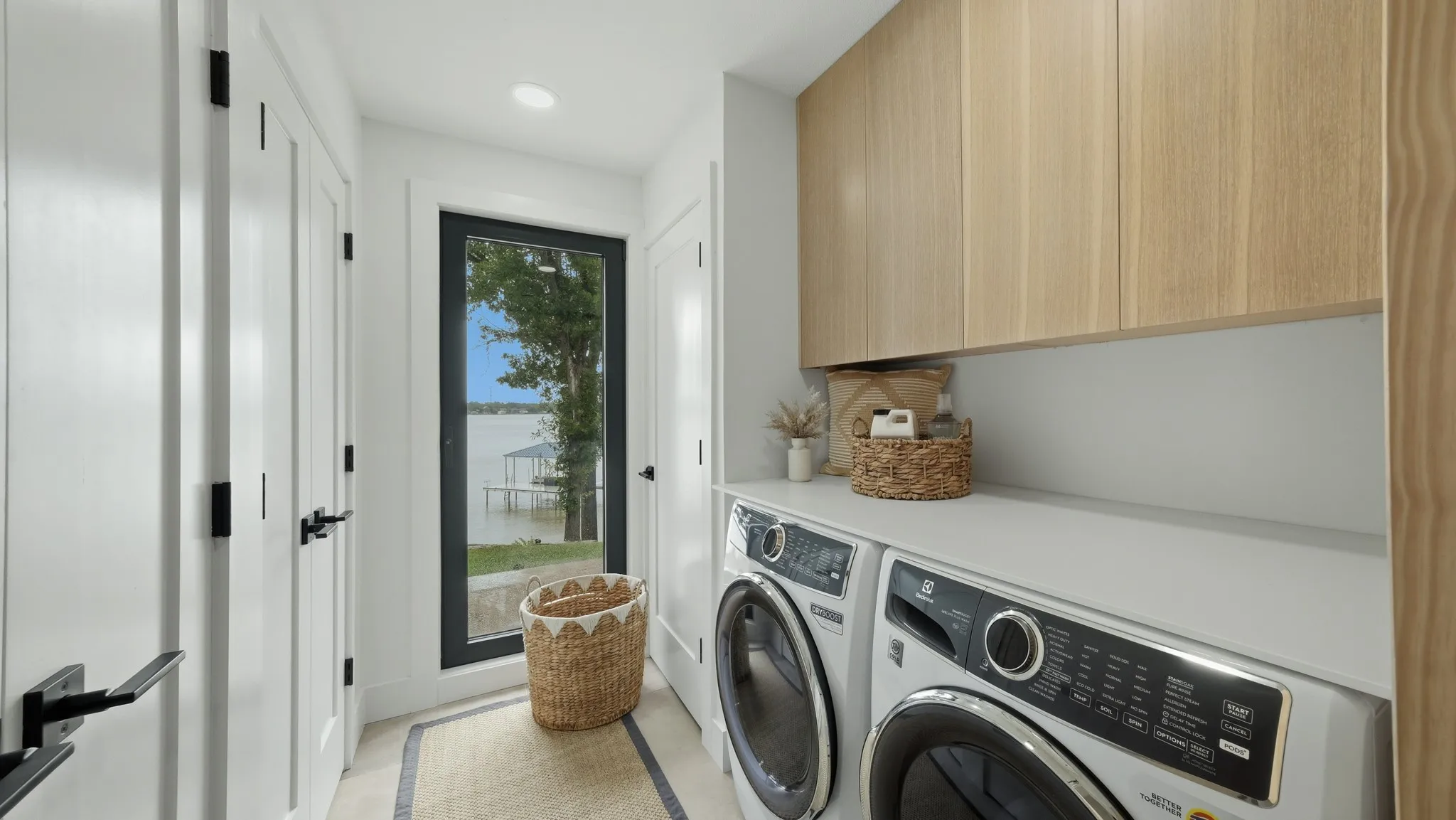 Laundry room featuring a white countertop, wood-finish cabinetry, and a full-light door