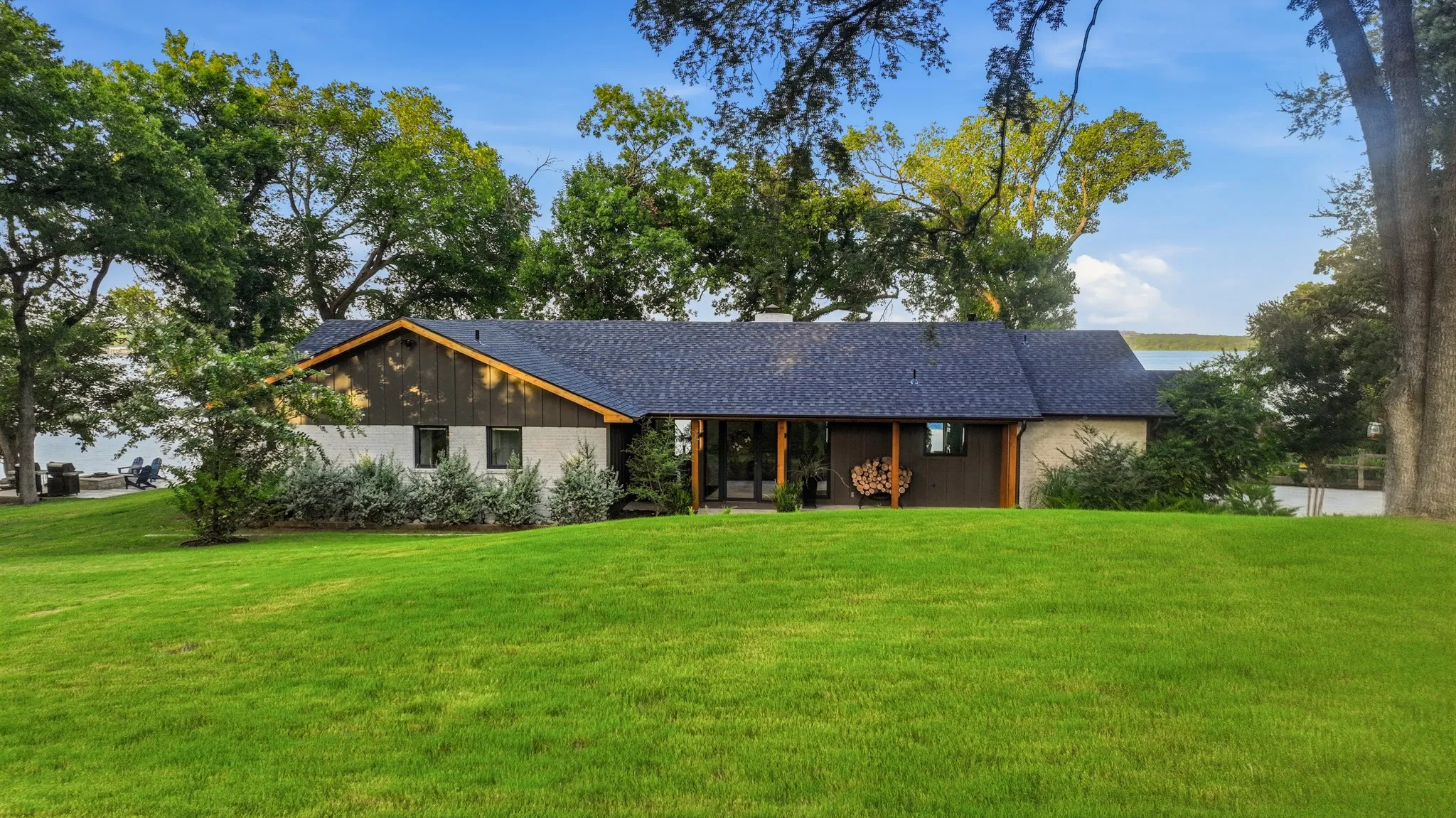 Ranch-style exterior with a dark shingle roof and a combination of light-toned and dark wood siding