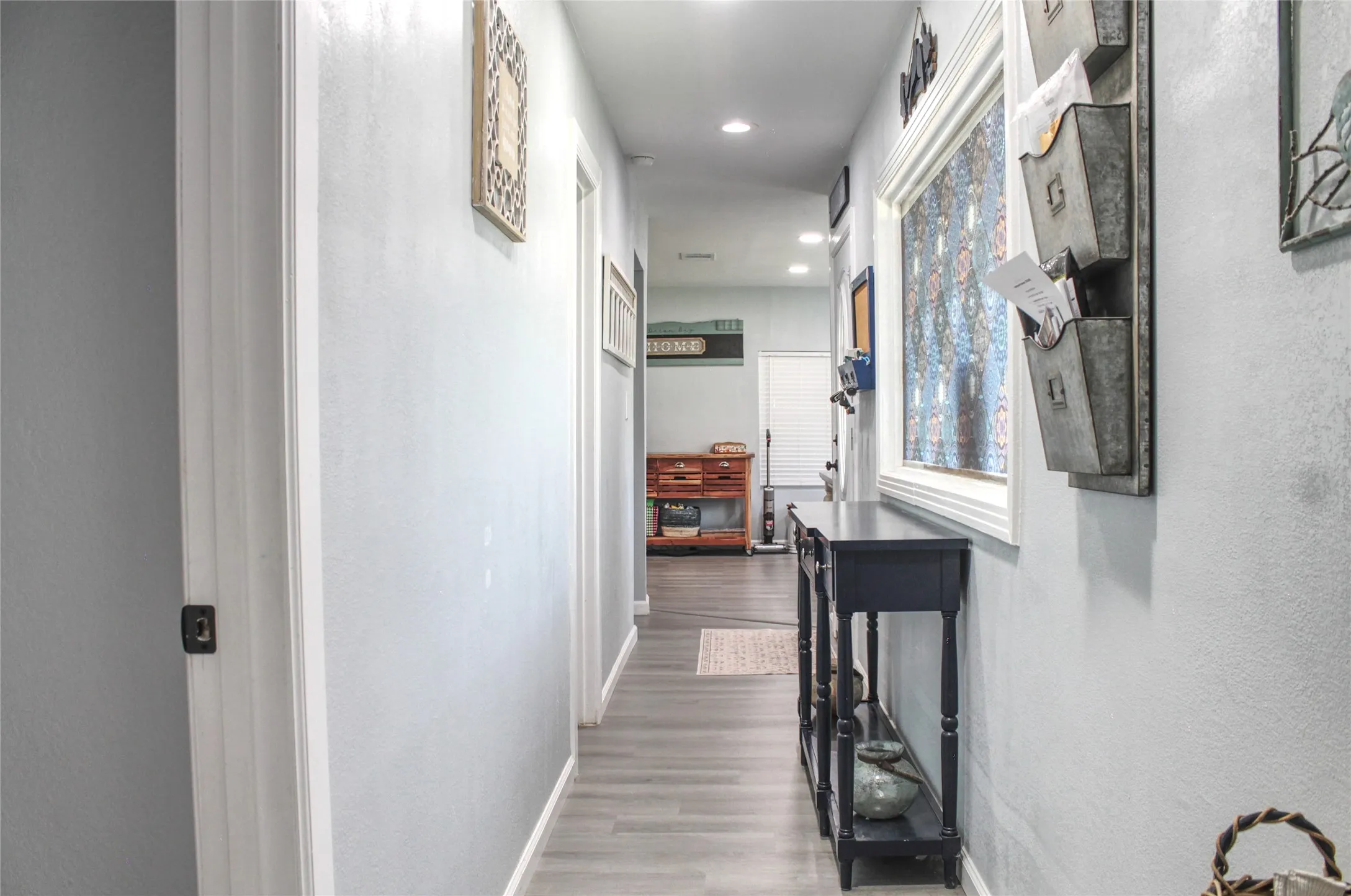 Hallway featuring light gray walls, white trim, recessed lighting, and wood-finish flooring