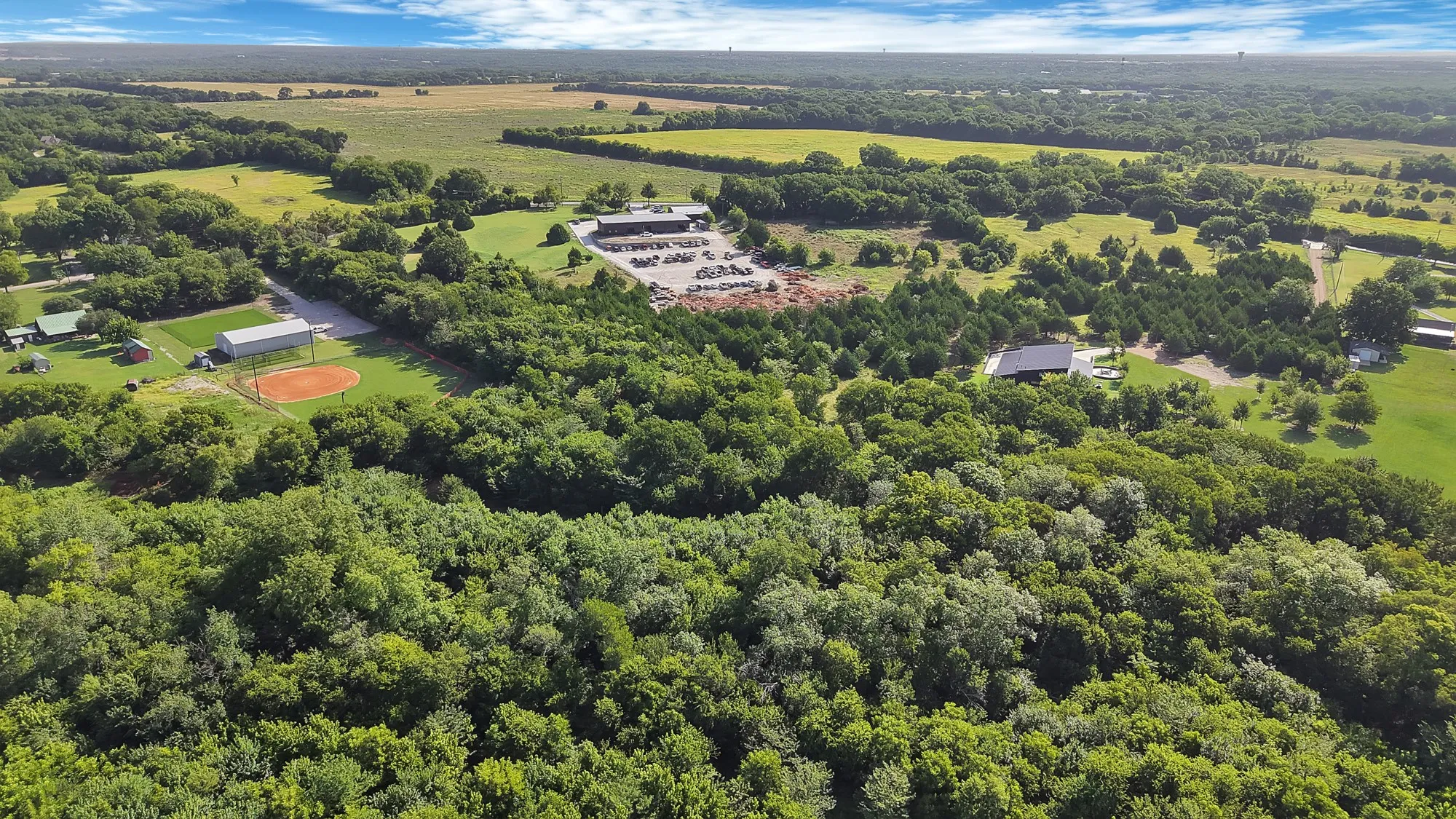 Expansive acreage featuring abundant mature trees, open fields, and diverse landscape