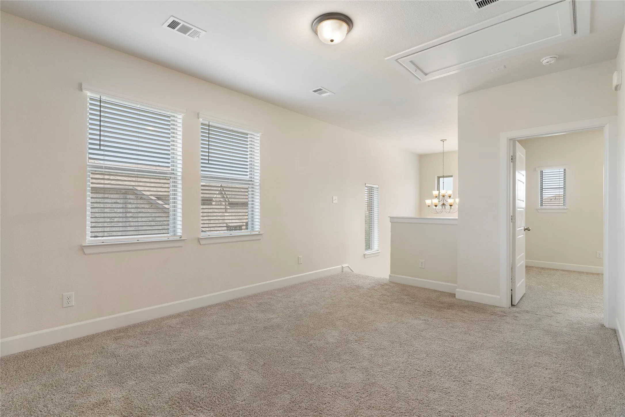 Carpeted flooring, multiple windows with blinds, recessed lighting, and a ceiling-mounted light fixture