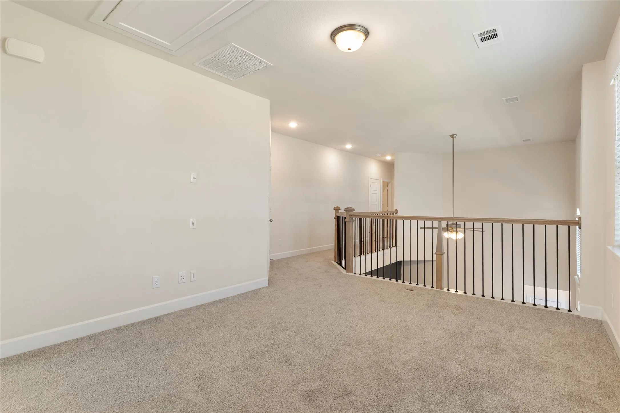 Loft space featuring neutral carpeting and light wall tones