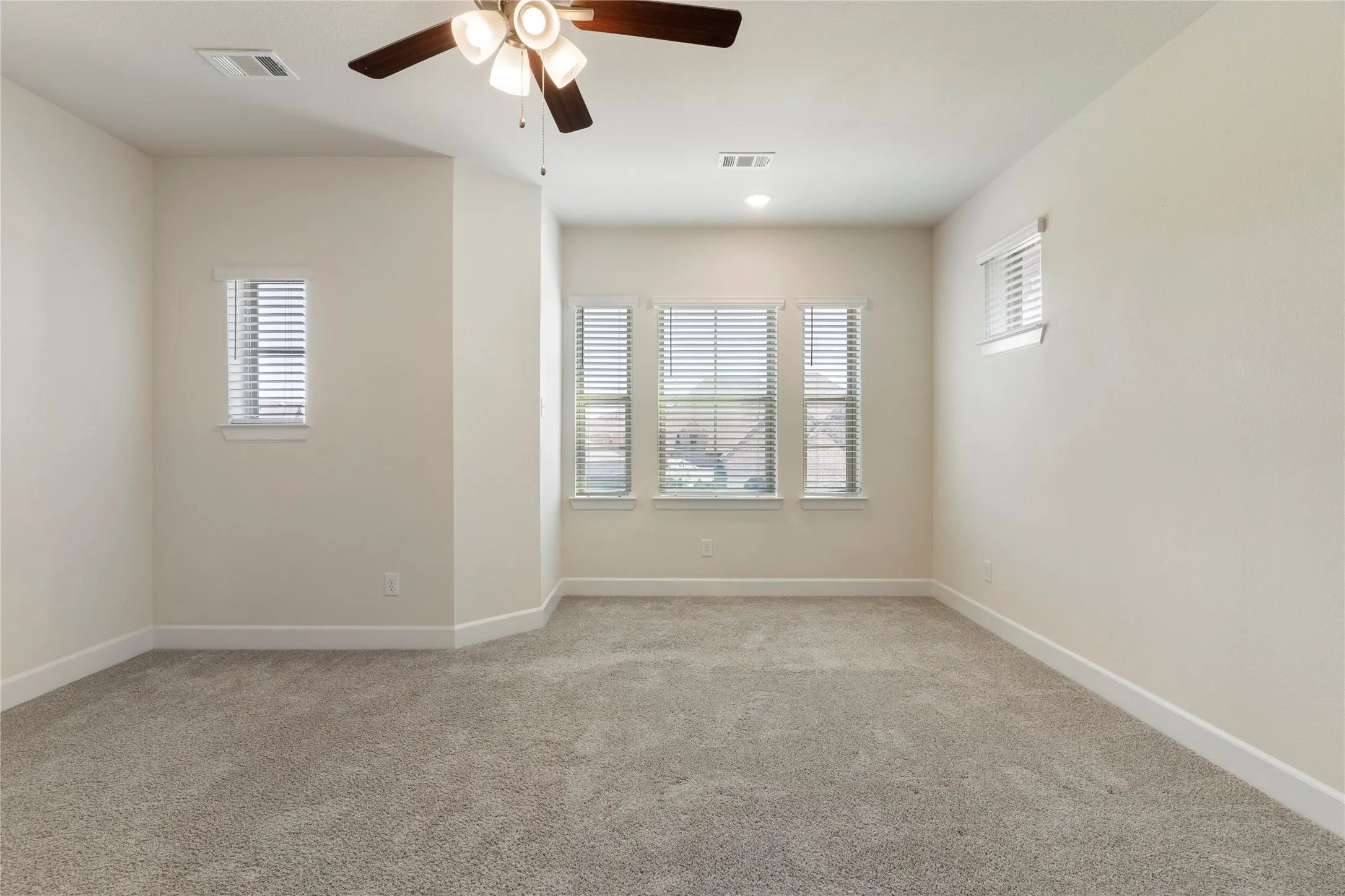 Plush carpeting with neutral walls, recessed lighting, and a ceiling fan with light fixture