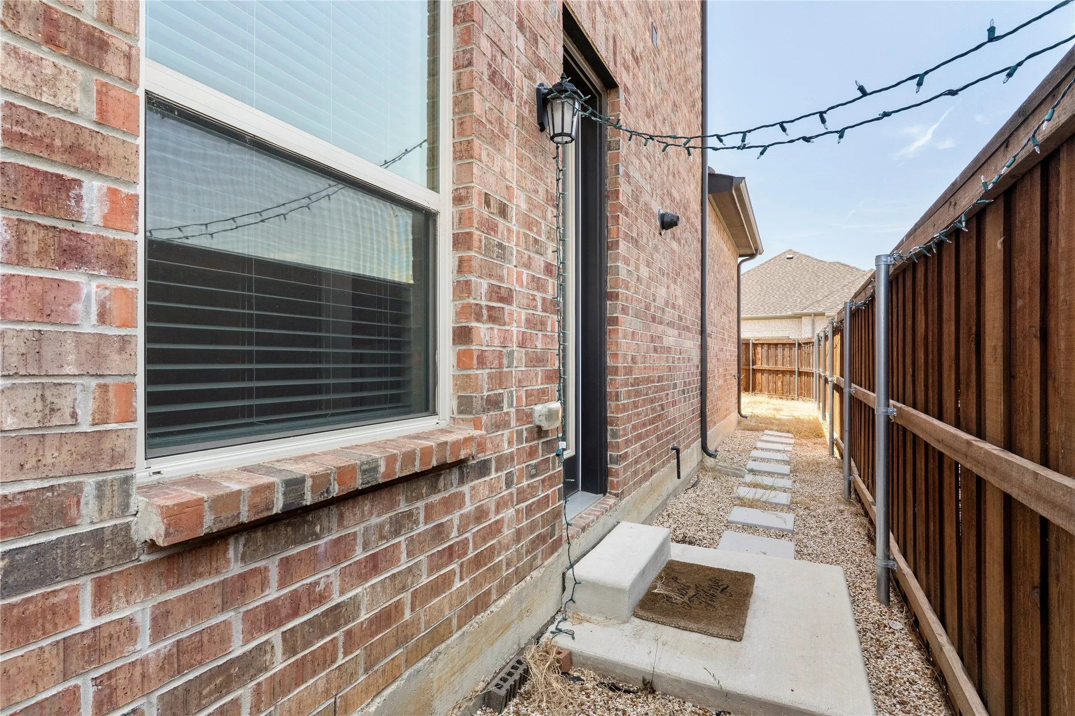 Brick exterior with a window and a pathway of stepping stones