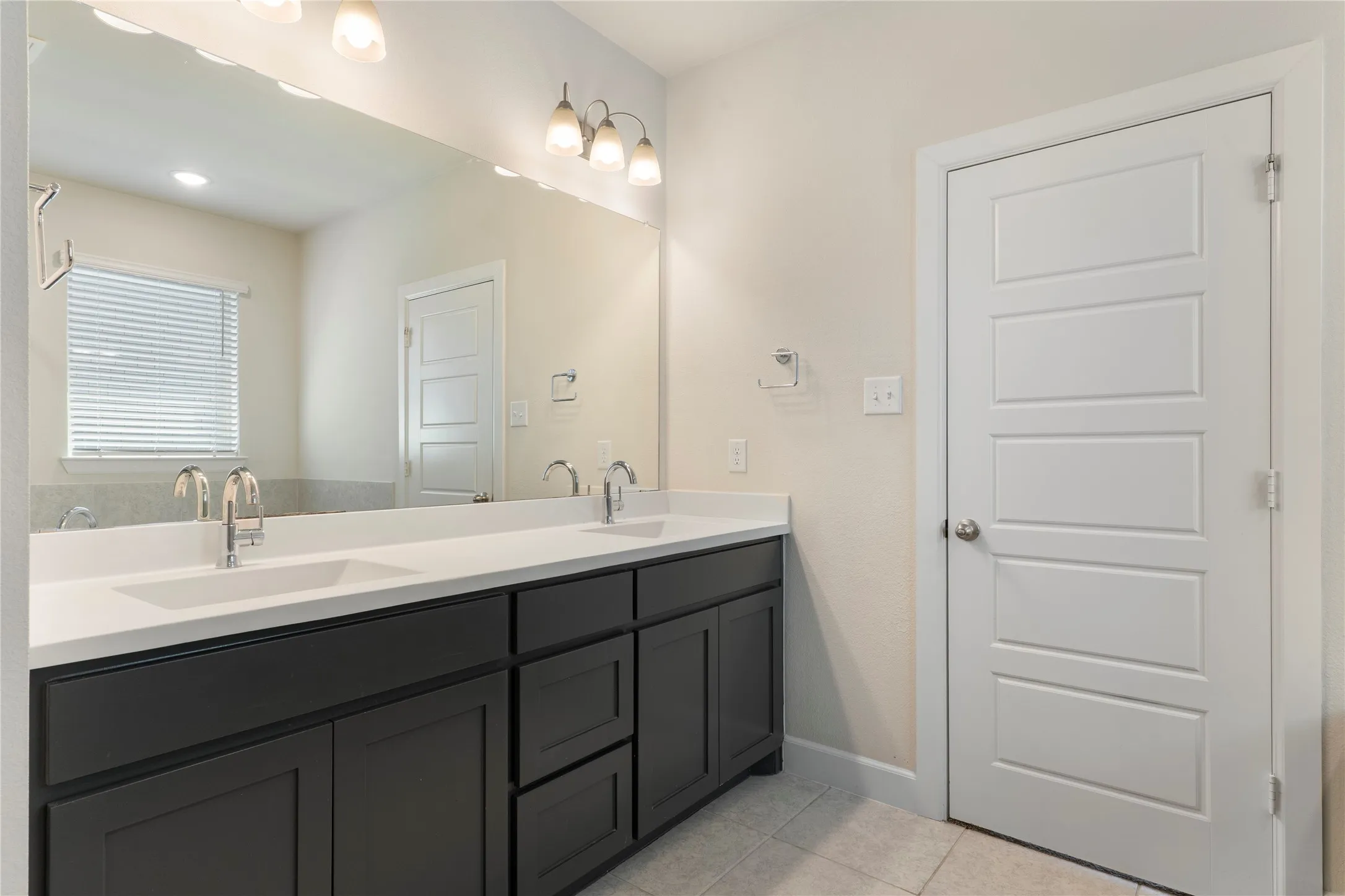 Dual vanity with integrated sinks, dark wood-finish cabinetry, white countertop, and individual chrome-finish faucets