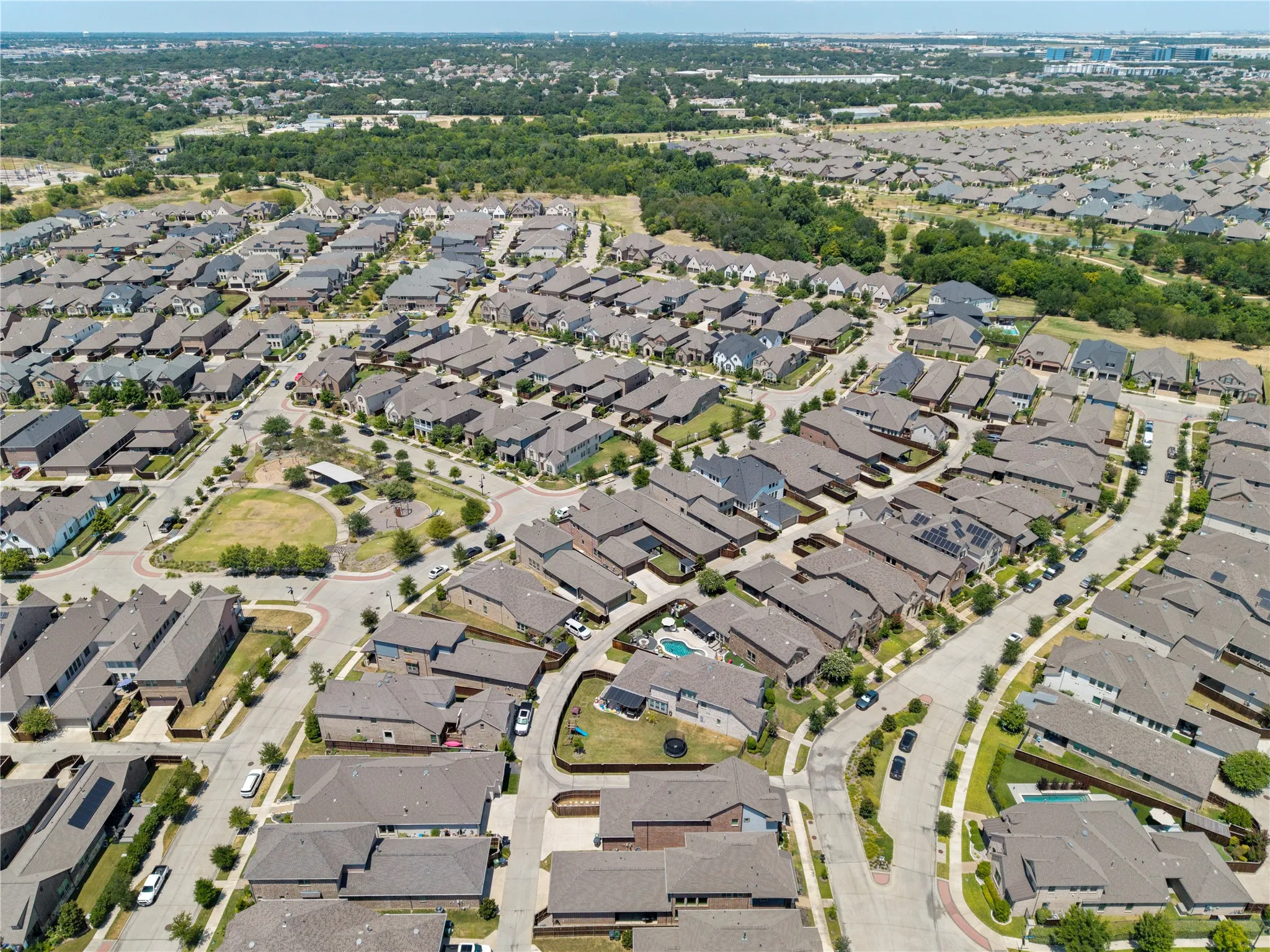 Residential neighborhood featuring multiple single-family homes, paved roads, and green spaces