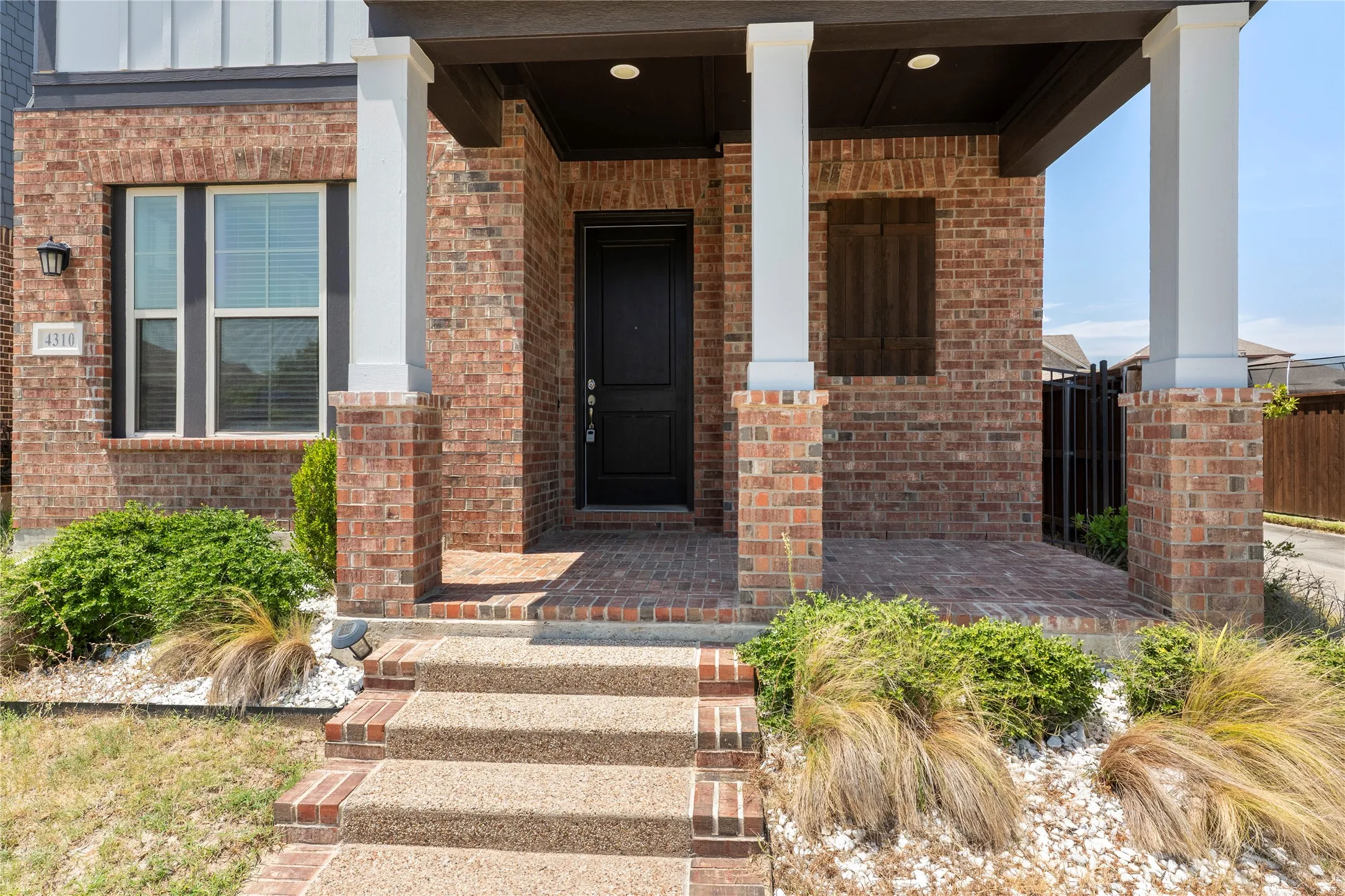 Brick exterior with white columns and dark trim