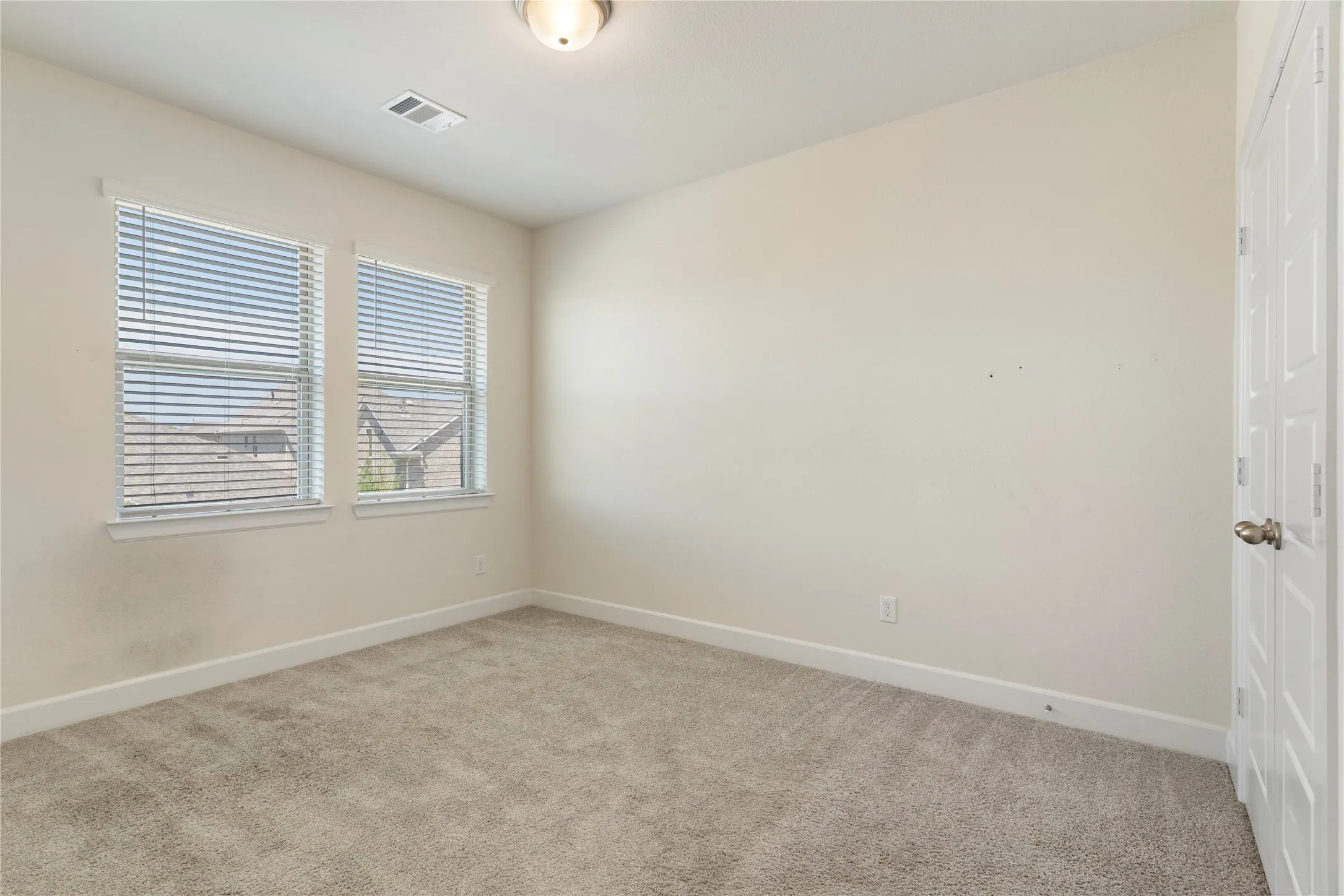 Neutral-toned walls complement the plush carpet flooring