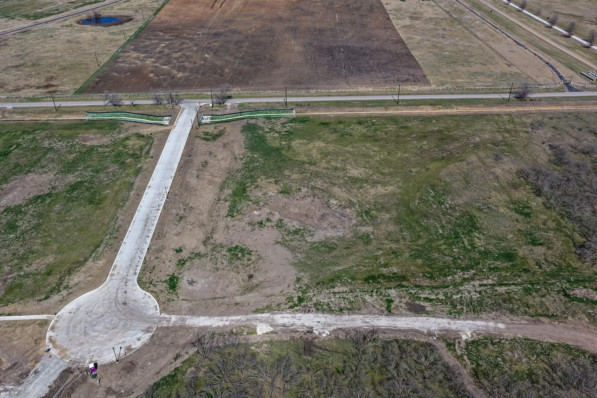 Developing land parcel featuring a newly paved entrance road with a cul-de-sac