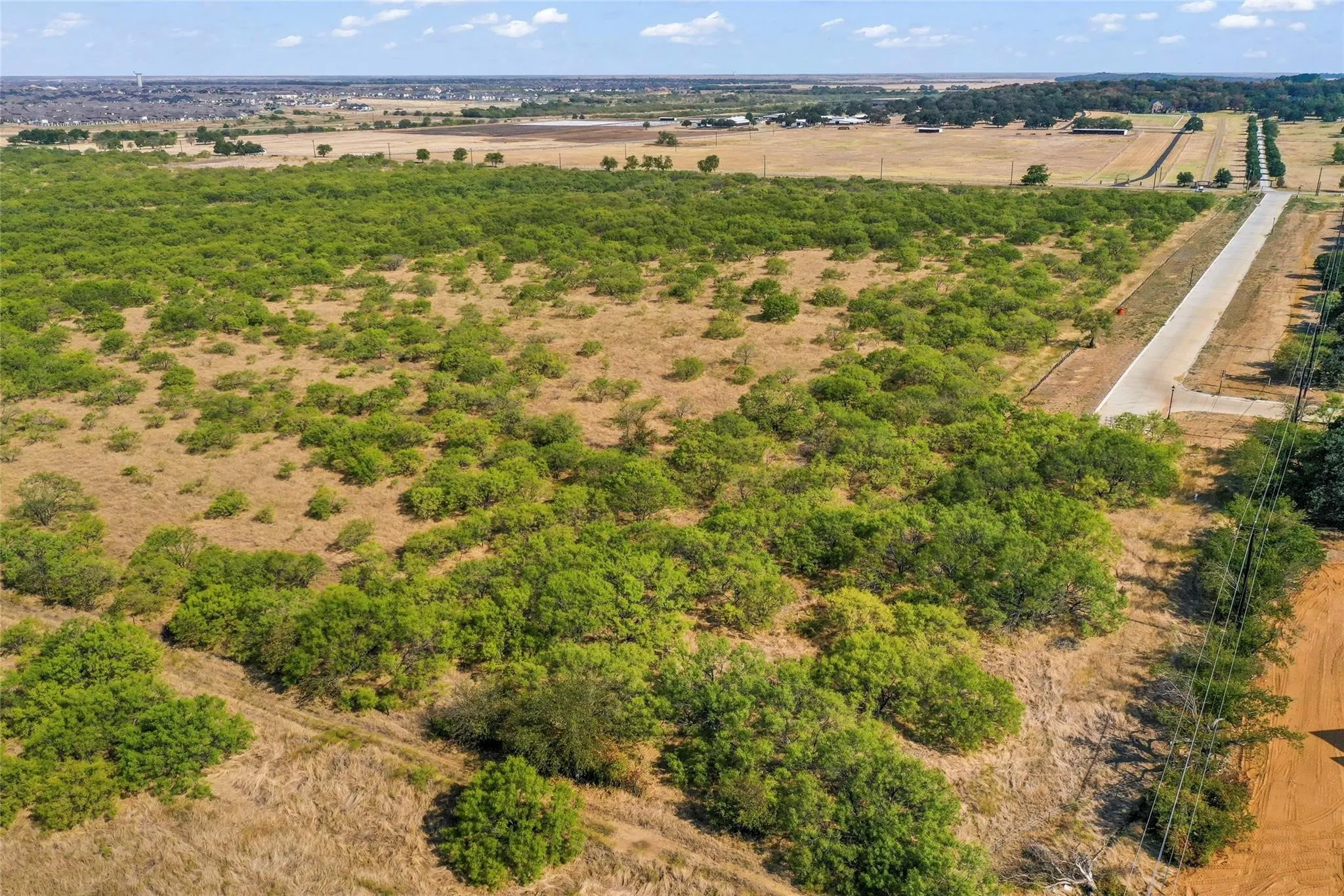 Expansive land parcel featuring natural shrubbery and dry grasses