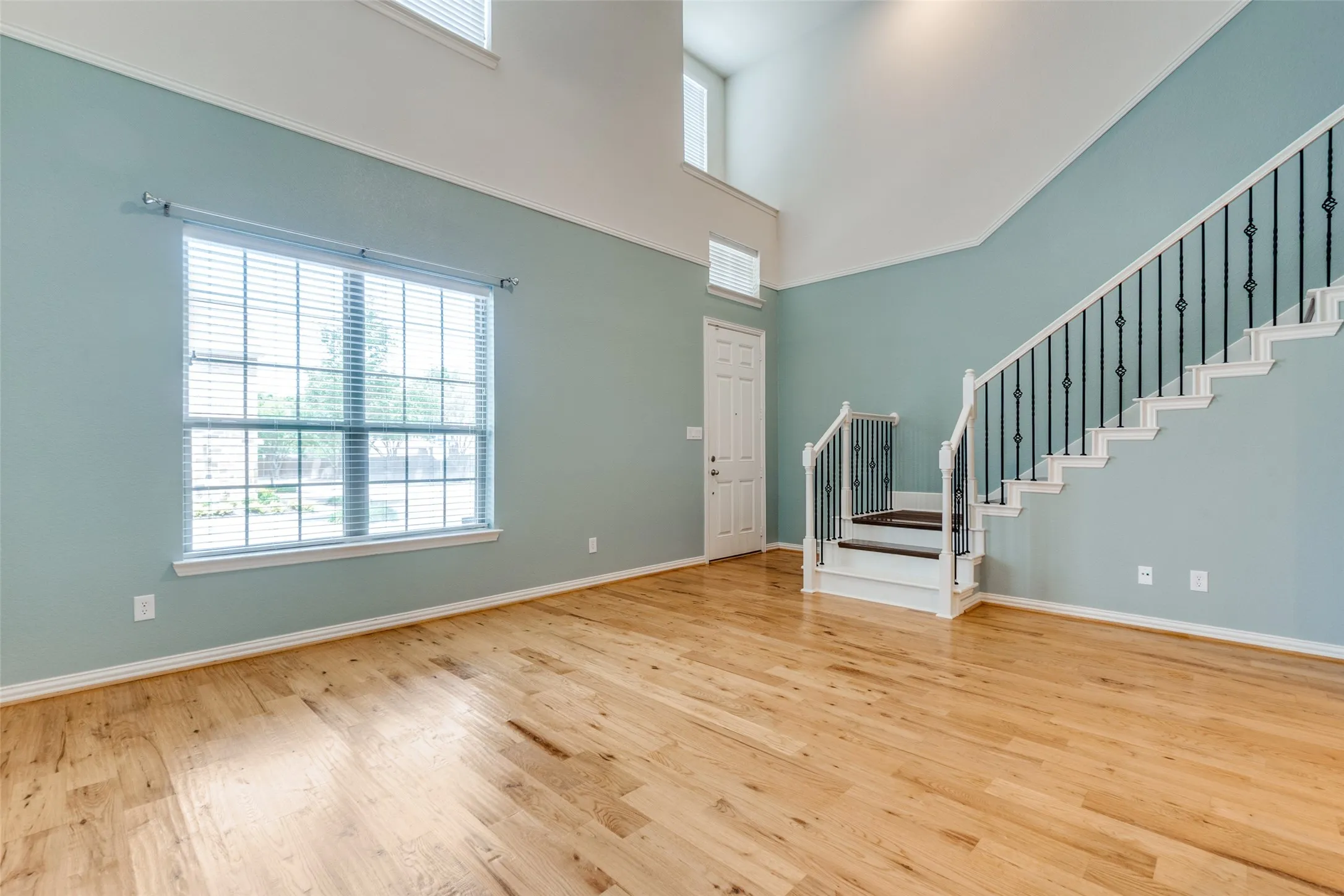 Entrance foyer with stairway, plenty of natural light, wood finished floors, and a towering ceiling