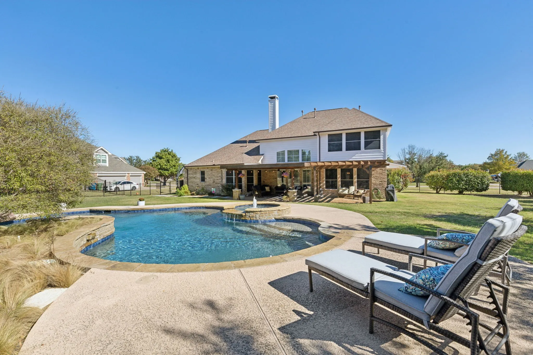 View of the pool and large back yard looking toward the back of the home.