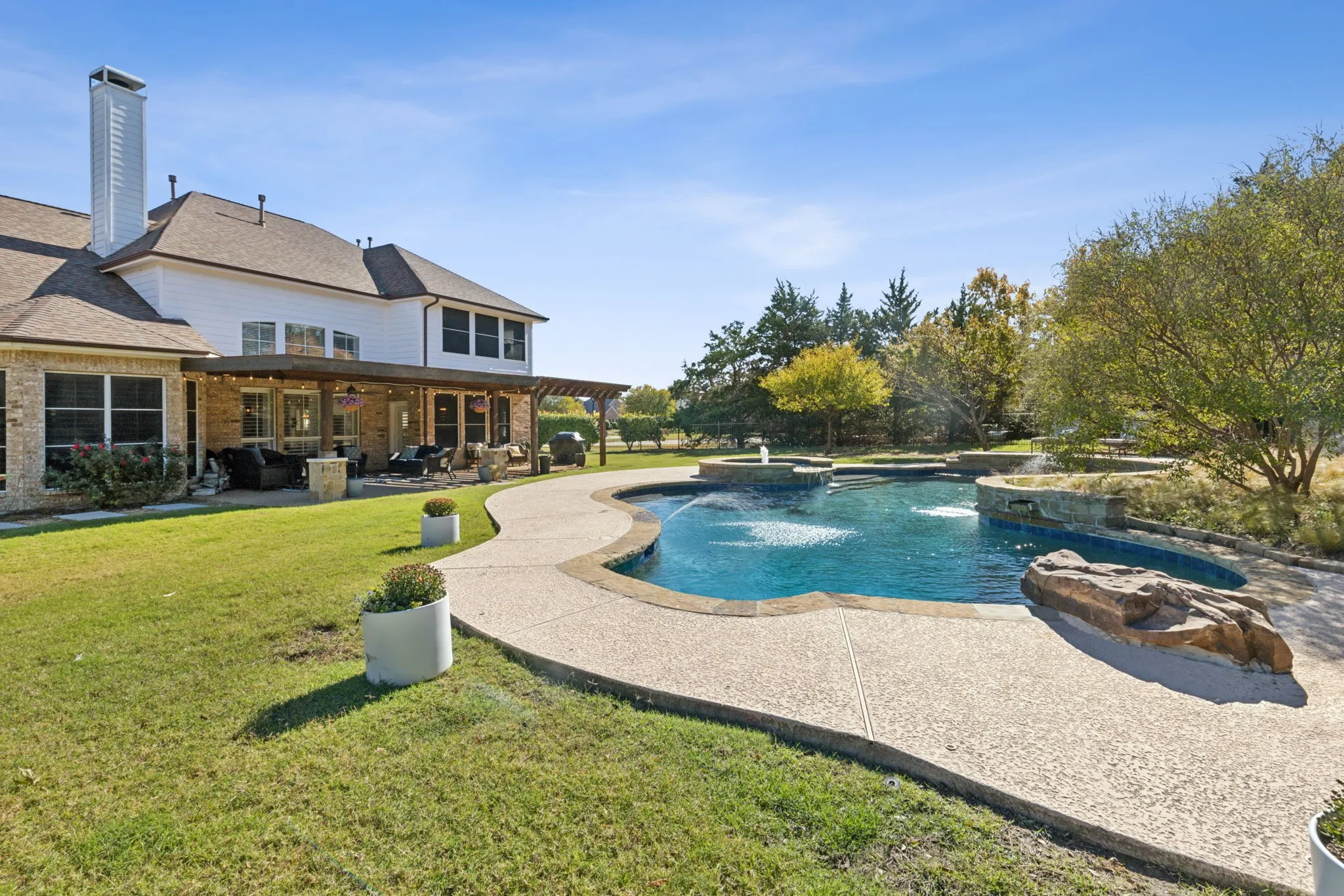 The backyard enjoys this refreshing pool while still providing space for pets and kids to run and play.