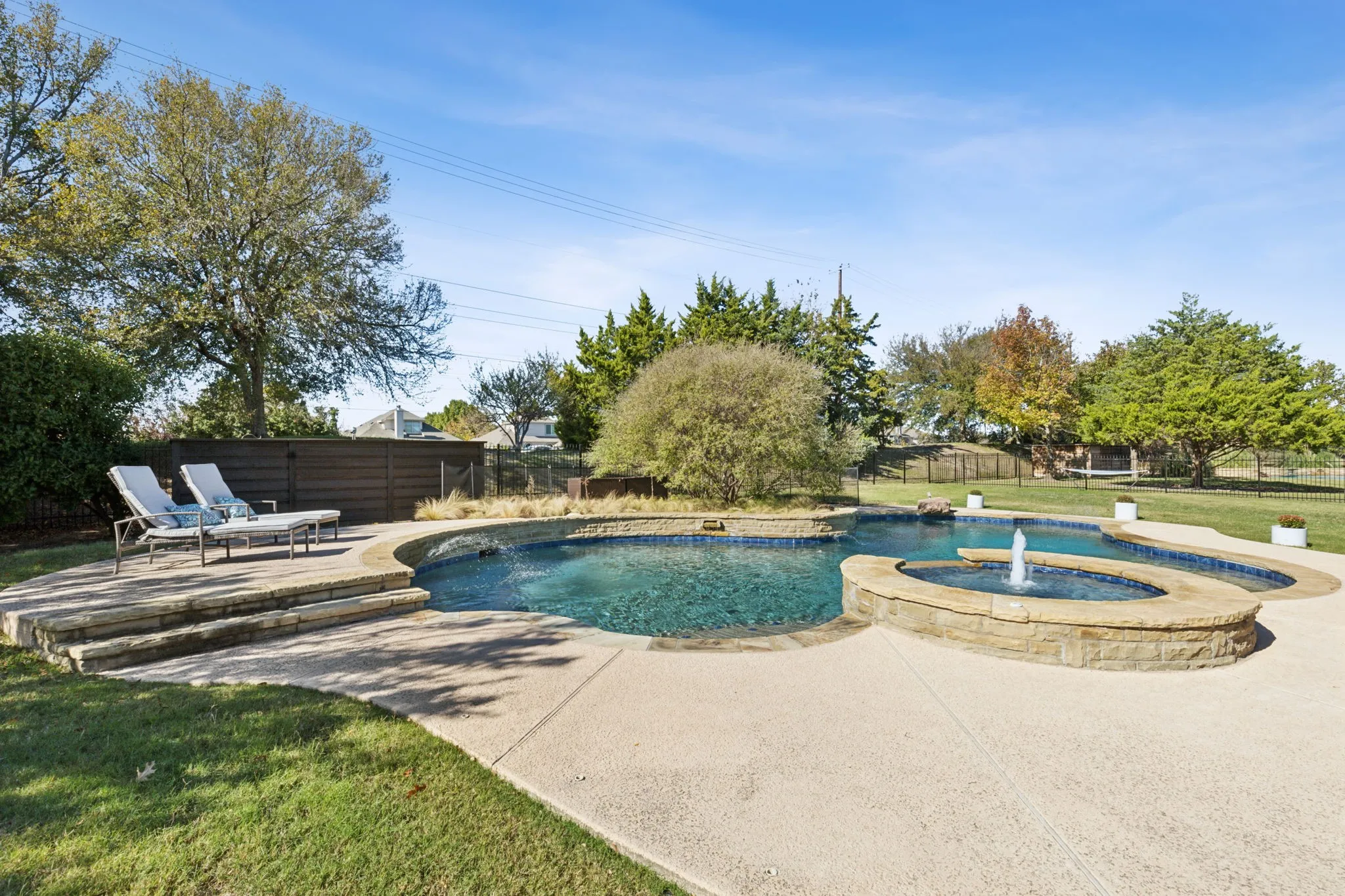 The pool has a generous deck with flagstone coping and water features.
