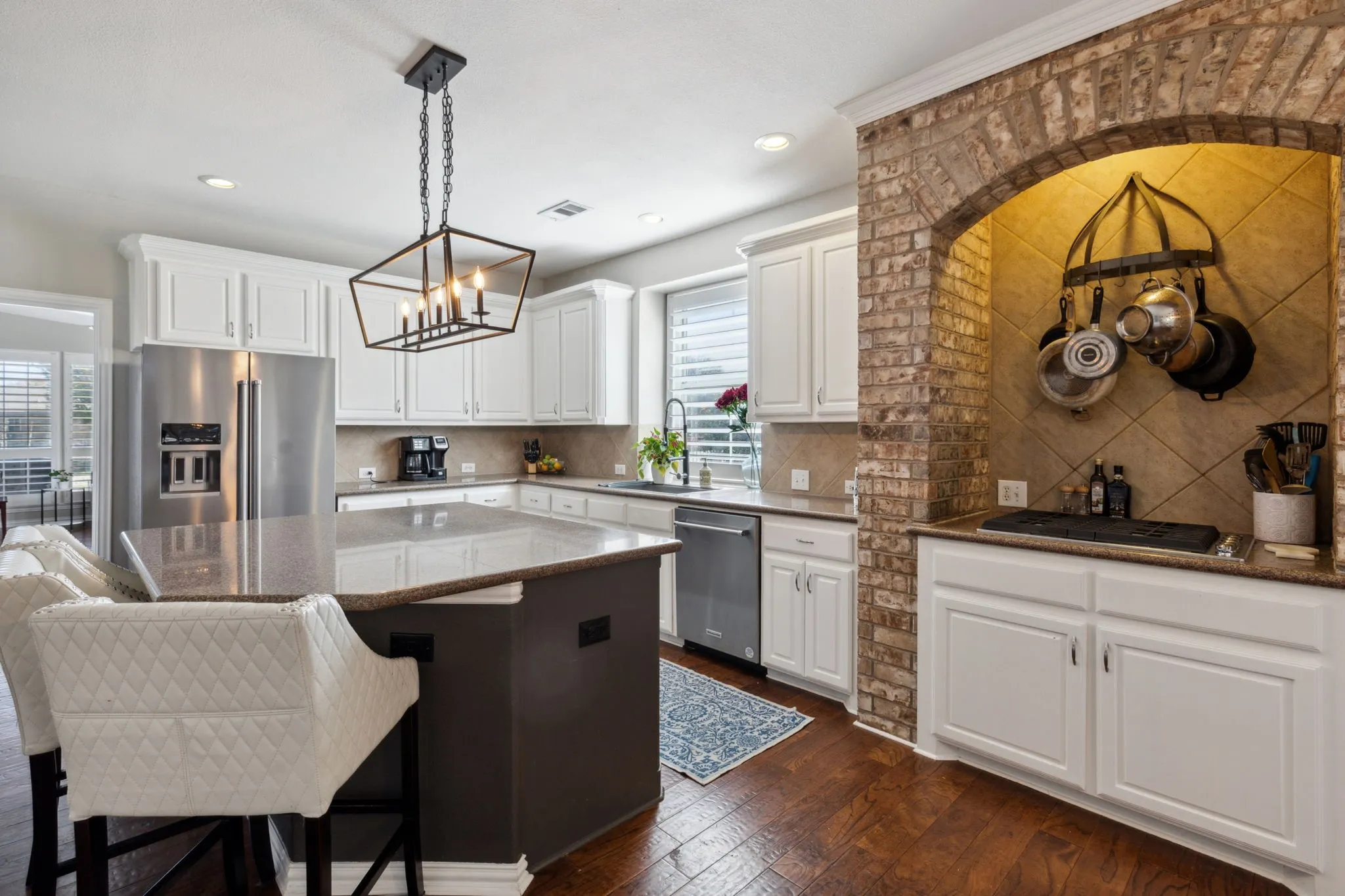 The oversized island provides additional dining spaces for a casual meal or overflow seating when entertaining. Other features of the space include refrigerator, recessed lighting and updated light fixture over the island.