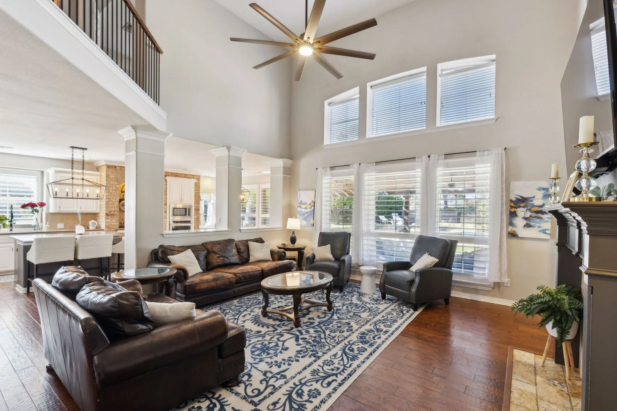 Another view of the family room showcasing the openness of the space and great views. The room boasts hardwood flooring and an oversized ceiling fan.