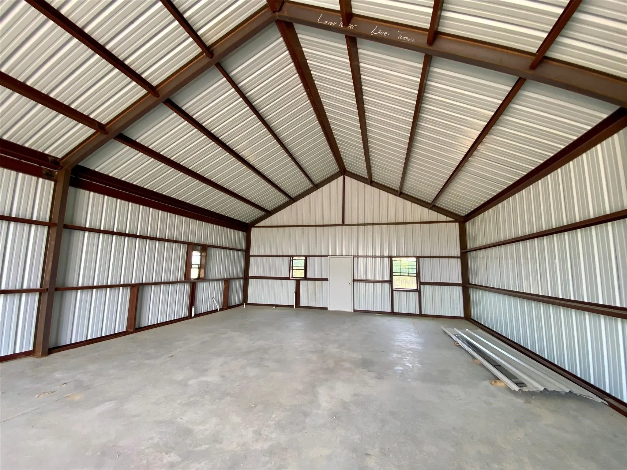 Spacious metal building featuring a vaulted ceiling and concrete flooring