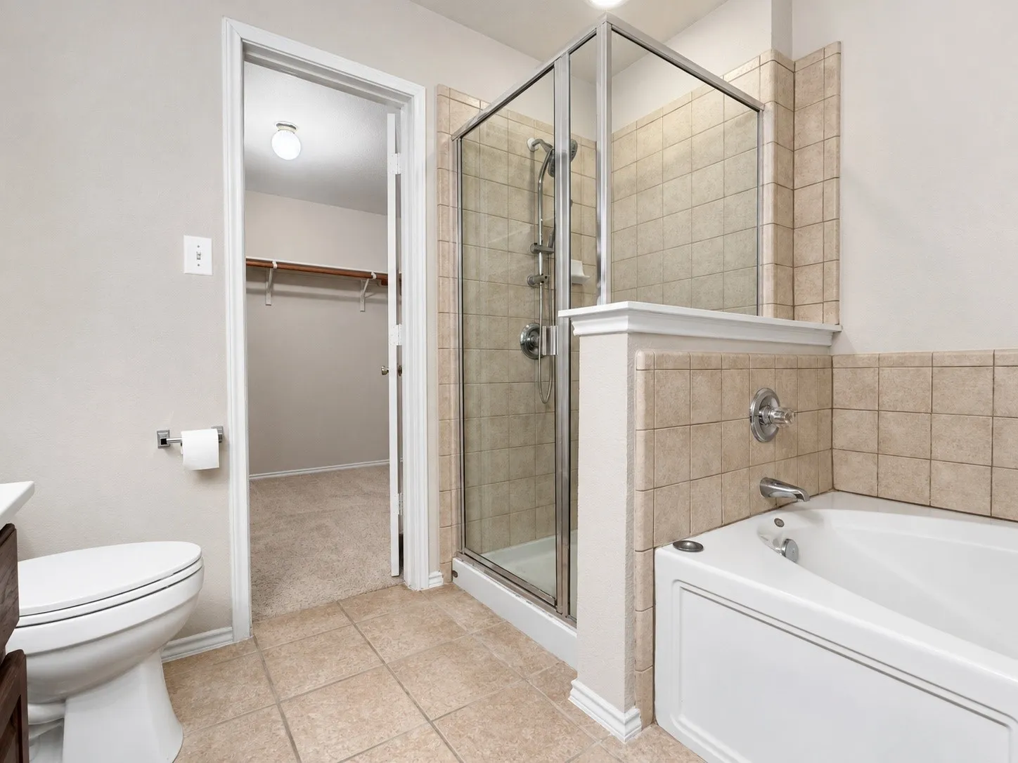 Downstairs primary bath includes separate tub and shower