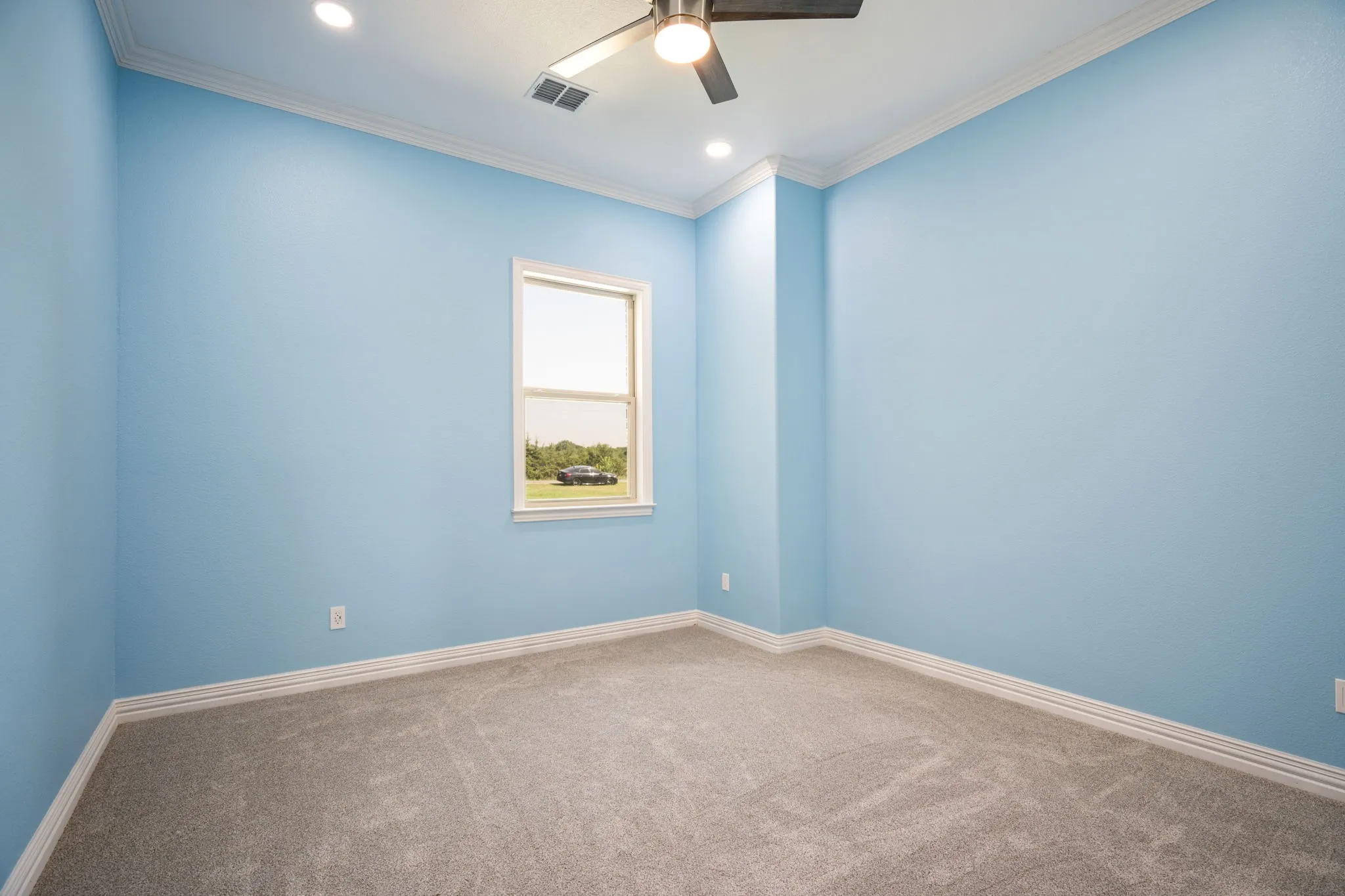 Carpeted room featuring a single window, crown molding, baseboards, and recessed lighting